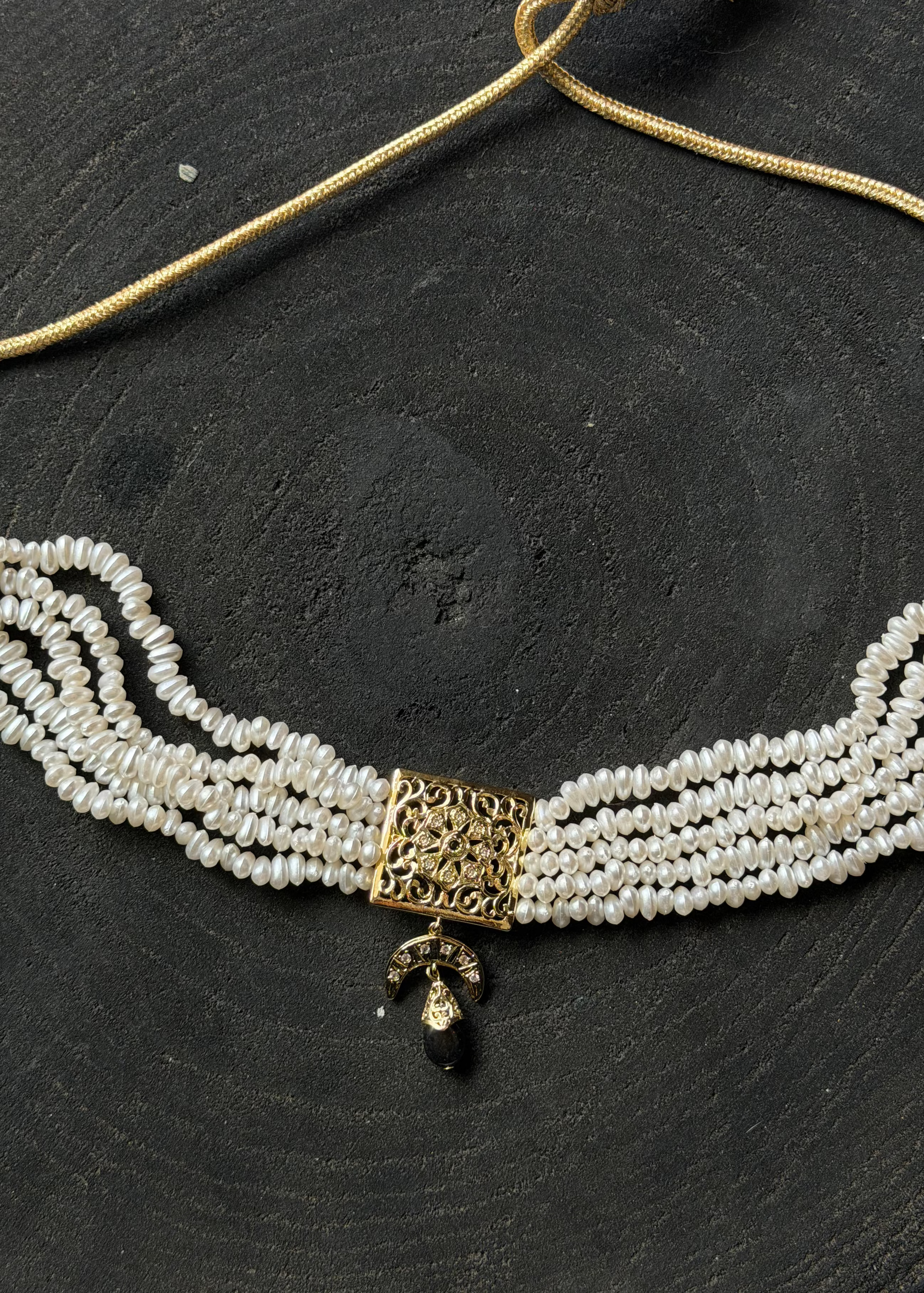 Gold and black beaded necklace worn close to the neck