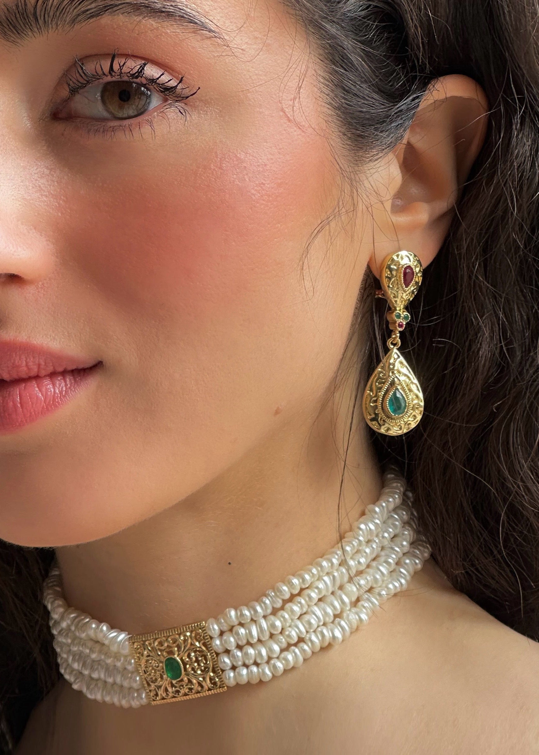 Worn pearl choker necklace, featuring pearlescent beads with gold accents and a green pendant—an elegant piece perfect for Kaftan formal attire