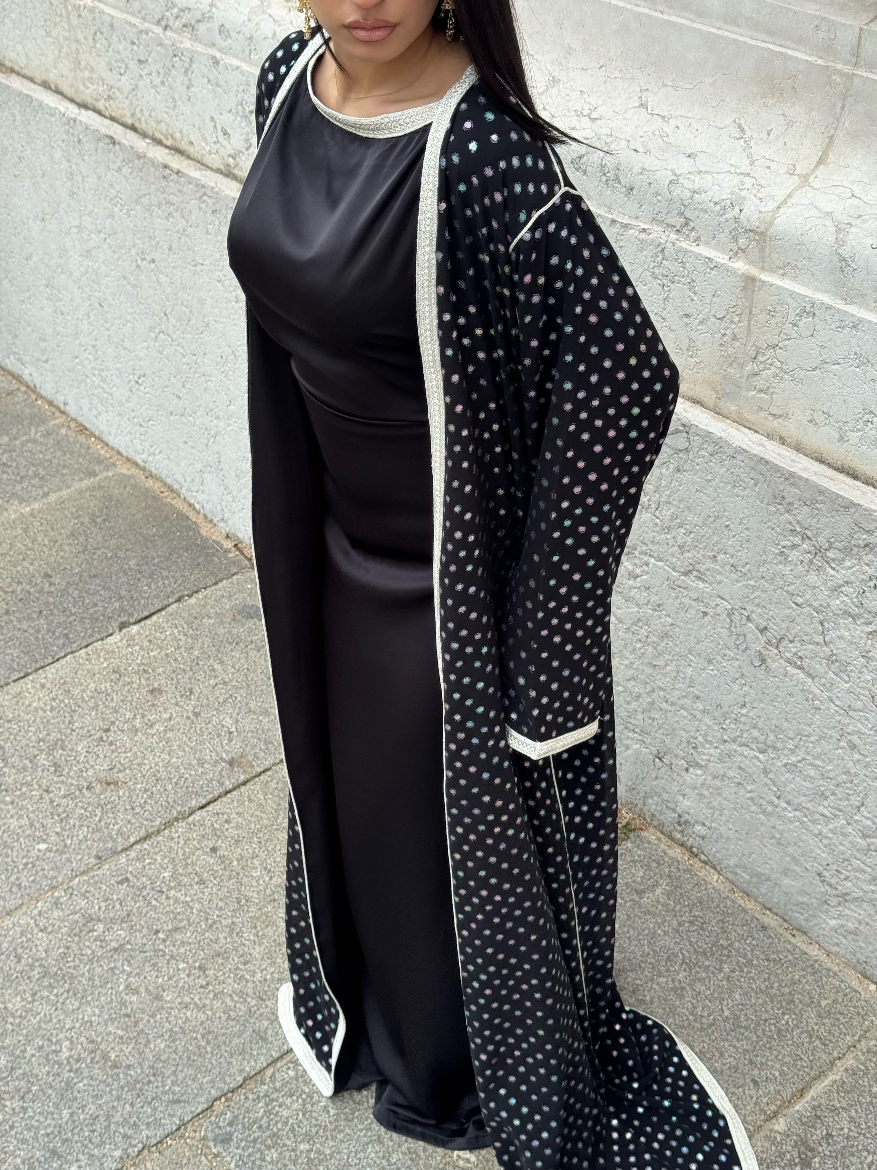 Abaya kimono noire à pois irisés portée sur robe satin noir – Selhyan