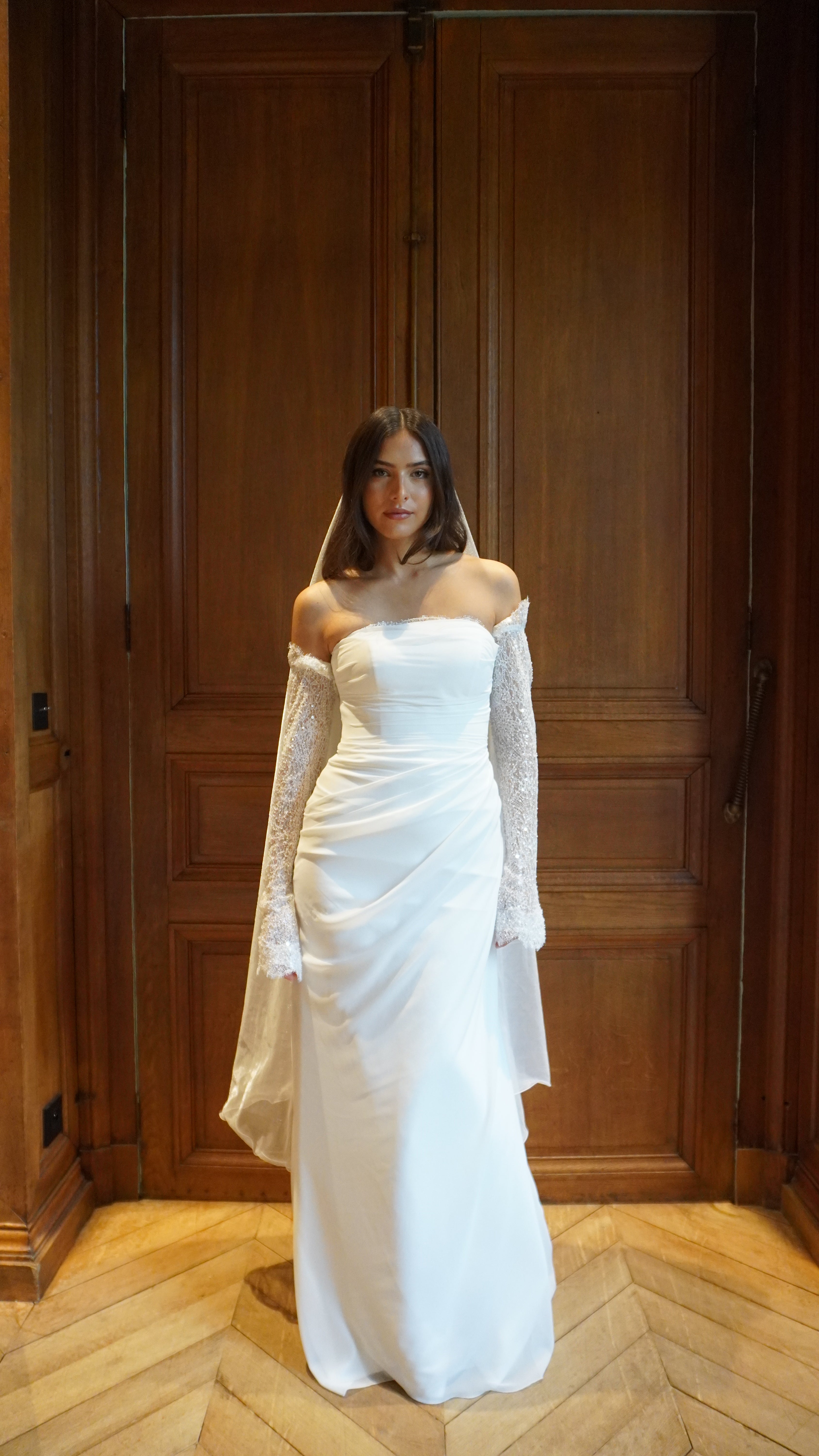 Vue en pied d’une mannequin portant les manches de mariée en dentelle perlée amovibles