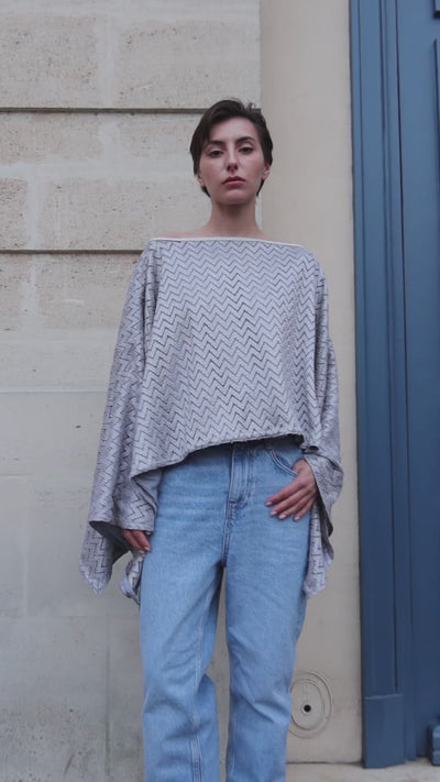 Vidéo d'une cape en jersey gris avec des zigzag et sfifa argentée portée sur mannequin en mouvement 