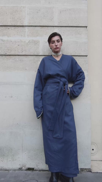 Vidéo portée d’un gilet long en cachemire bleu avec des détails de sfifas sur les manches. 