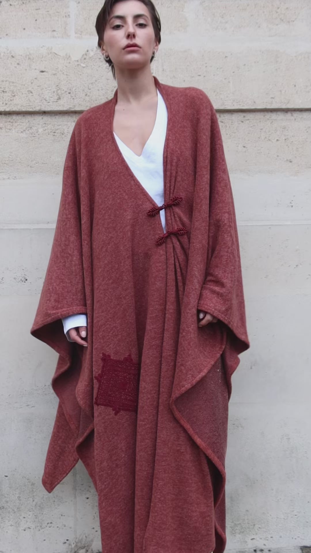 vidéo d'un gilet long bohème en laine bordeaux avec des broderies artisanal et des boutons marocains portée sur mannequin en mouvement