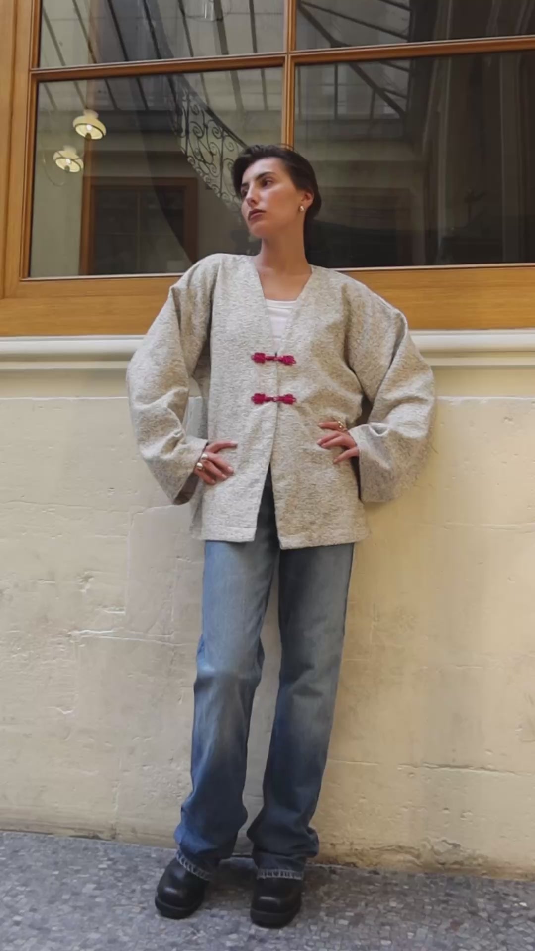 Vidéo portée de la veste en laine bouclée vert et beige à boutons marocains roses. 