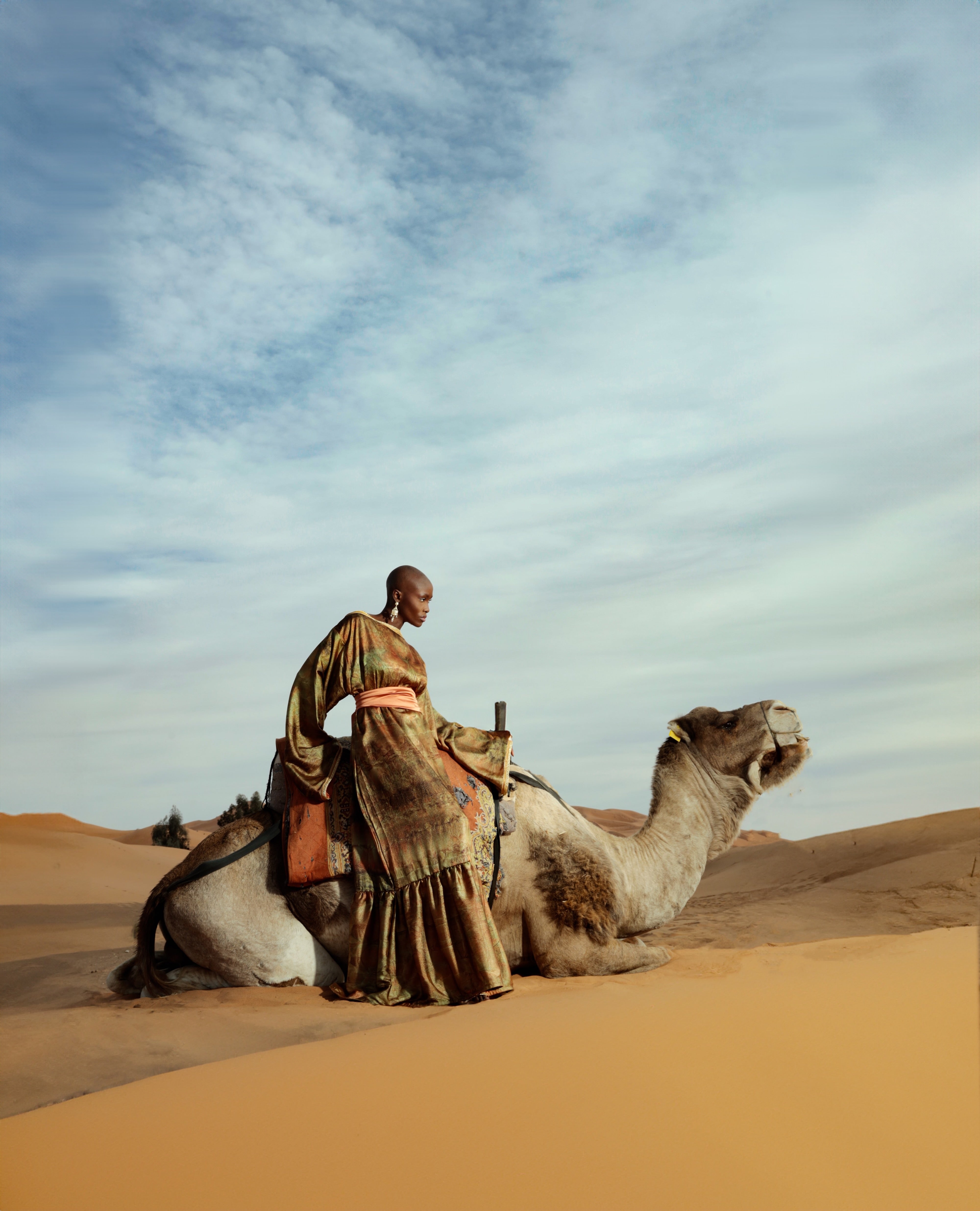 Robe longue en satin imprimé vert kaki portée avec coupe fluide et élégante

