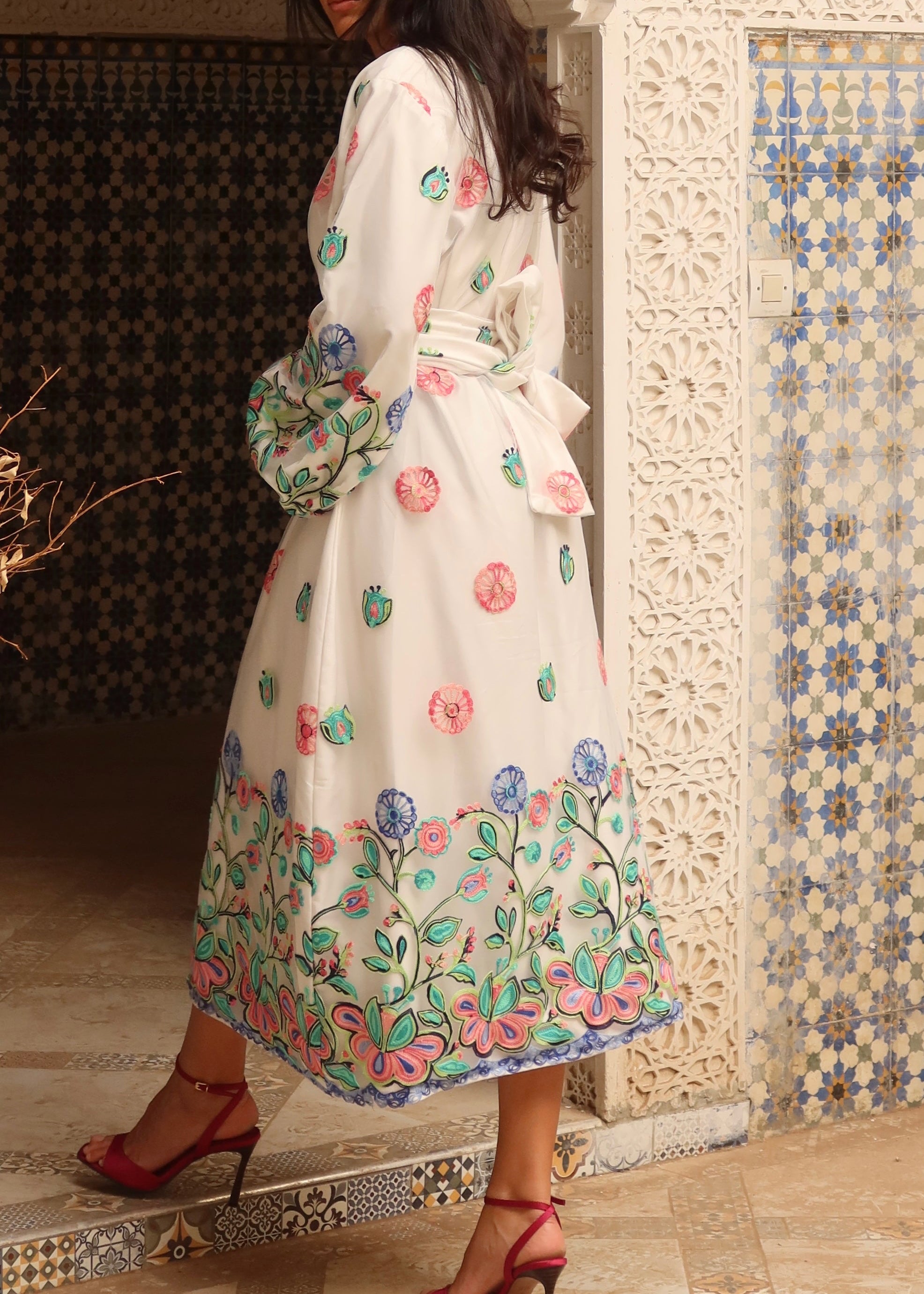 Détail du col V à galon rose et bouton rose, broderie fleurie – robe Selhyan