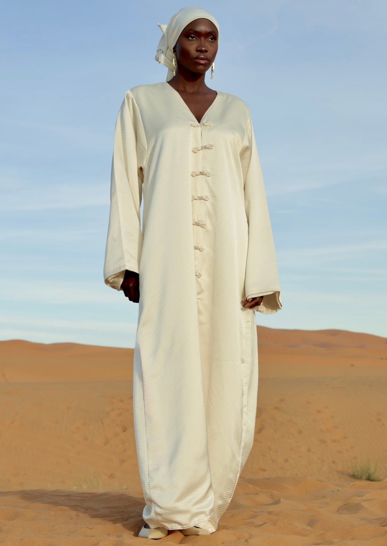 فستان أبيض من الساتان المطوي بأكمام واسعة، تم ارتداؤه في الصحراء – Selhyan