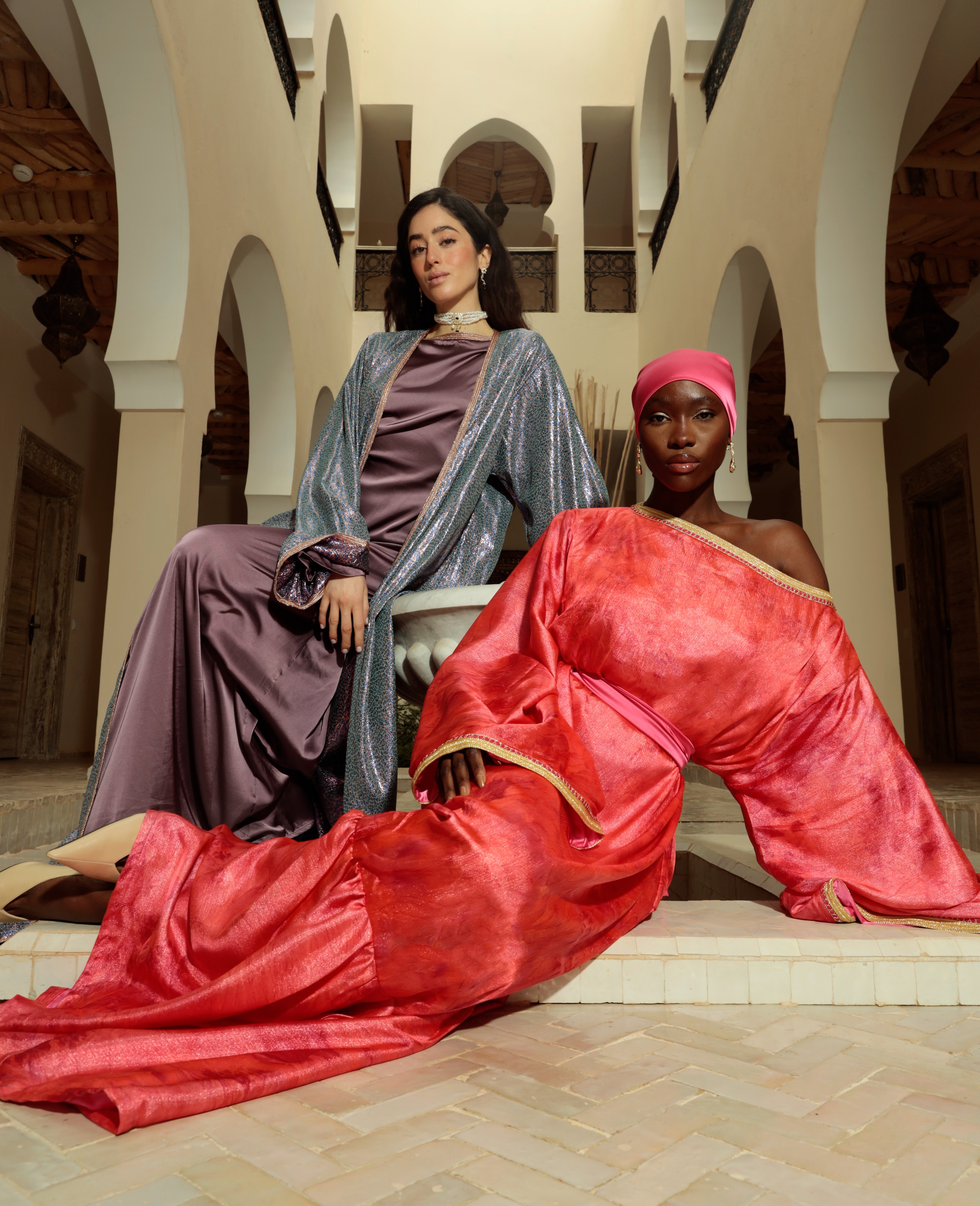 Robe en satin rose à manches longues portée allongée, avec une silhouette en kimono en arrière-plan
