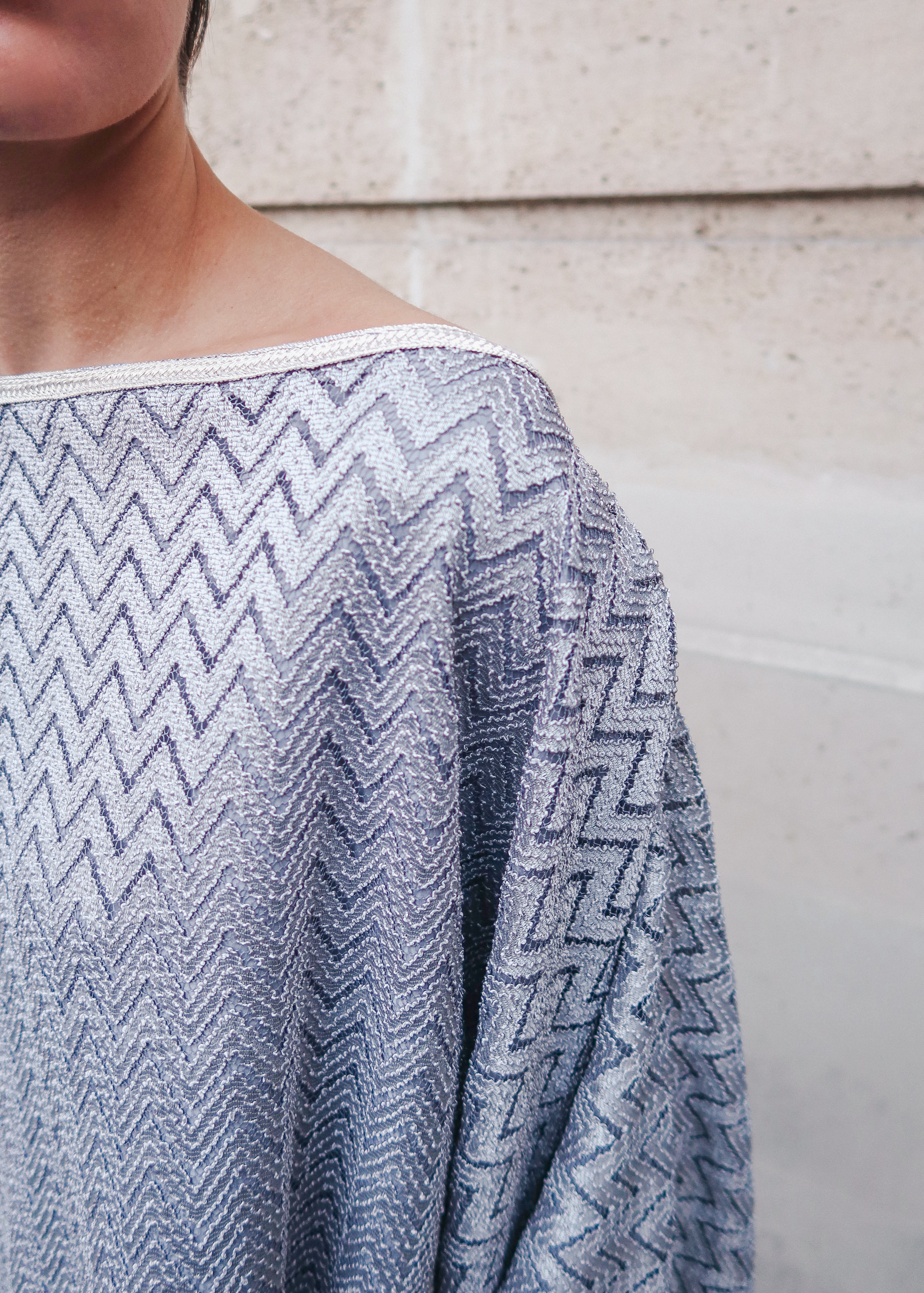 Gray jacquard top with a chevron pattern and wide, cape-style sleeves