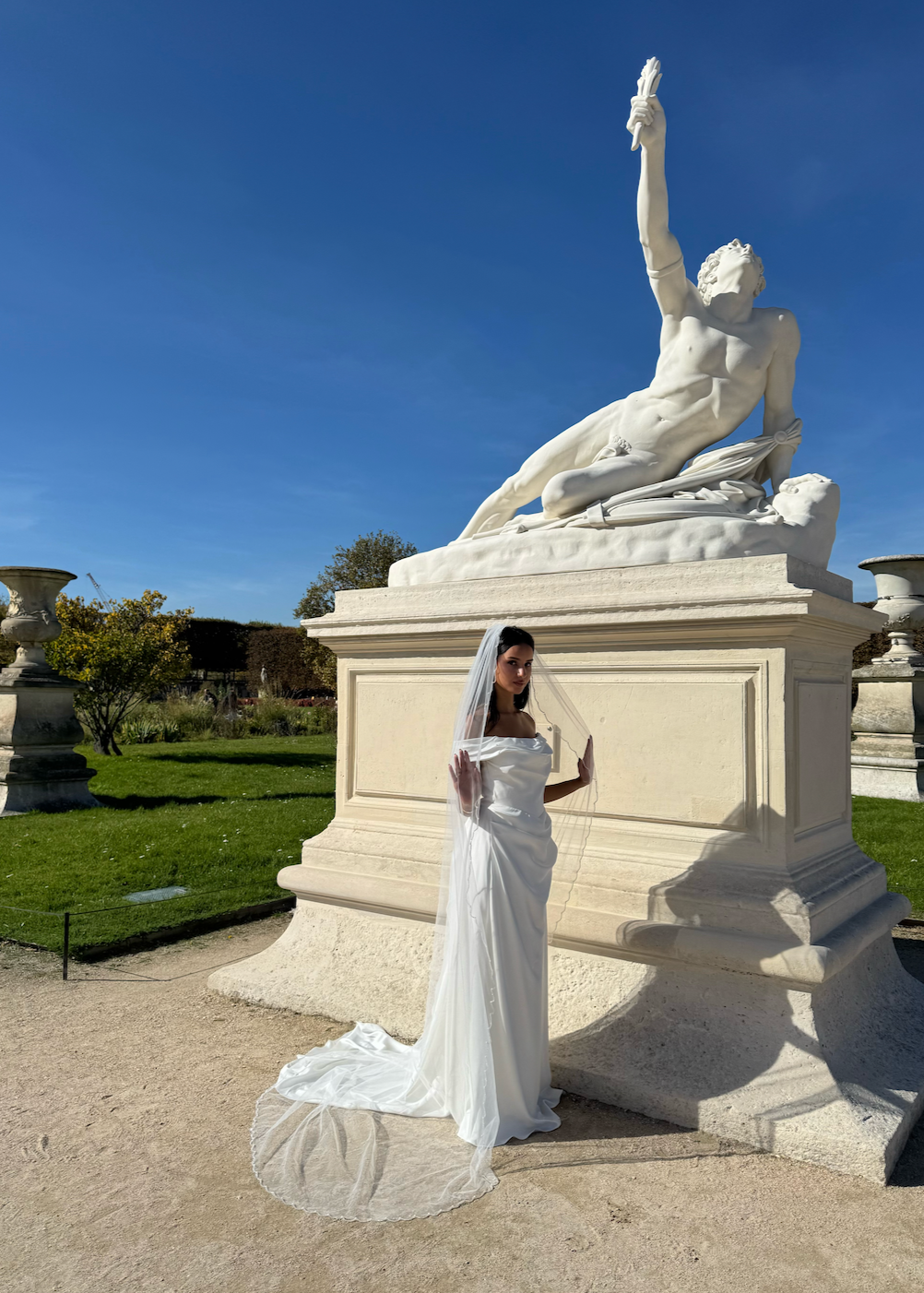 Vue de dos d’un voile de mariée long, tombant jusqu’au sol, avec bordure perlée ondulée.