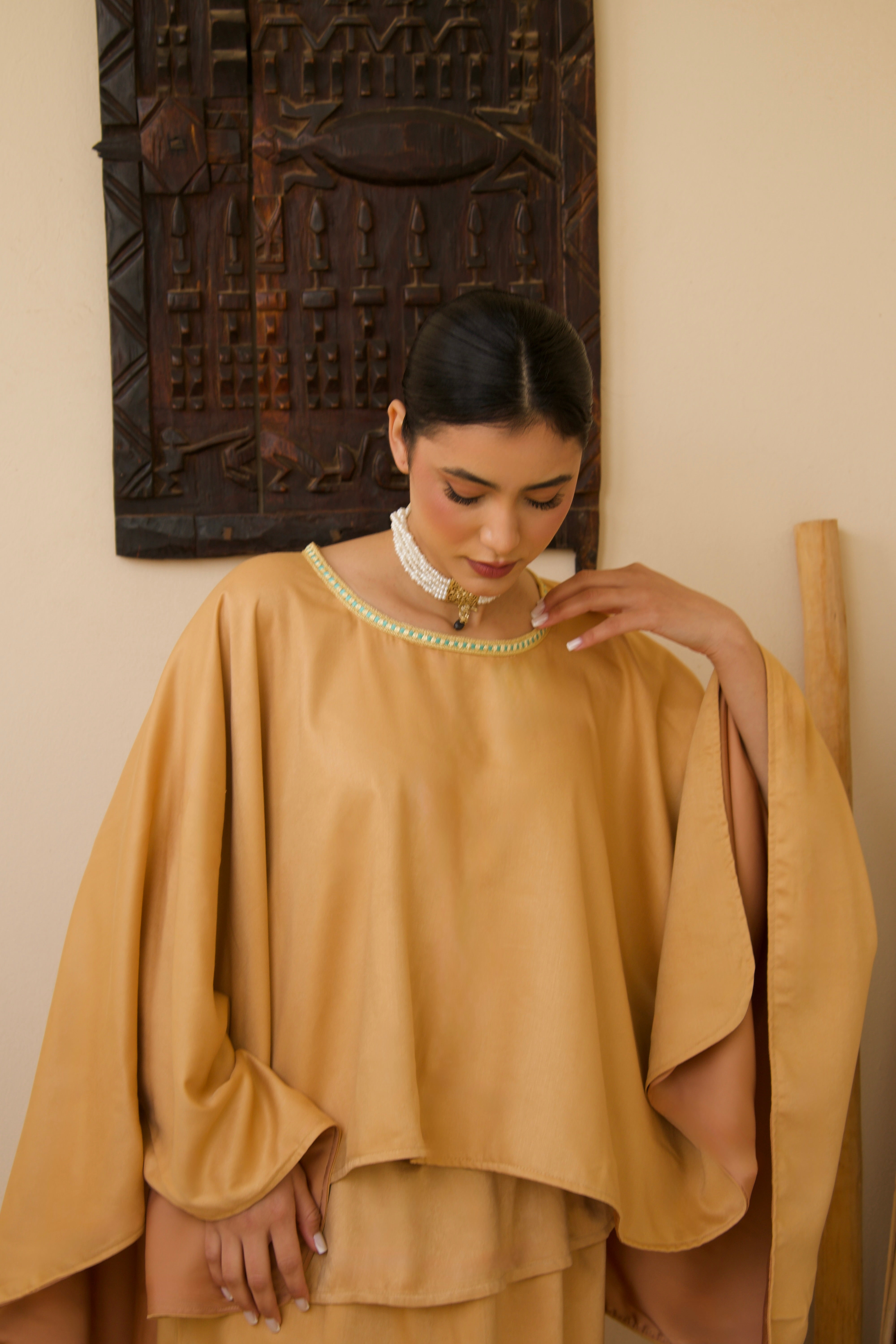 Close-up of the texture of the orange mlifa silk used for the cape and skirt ensemble.