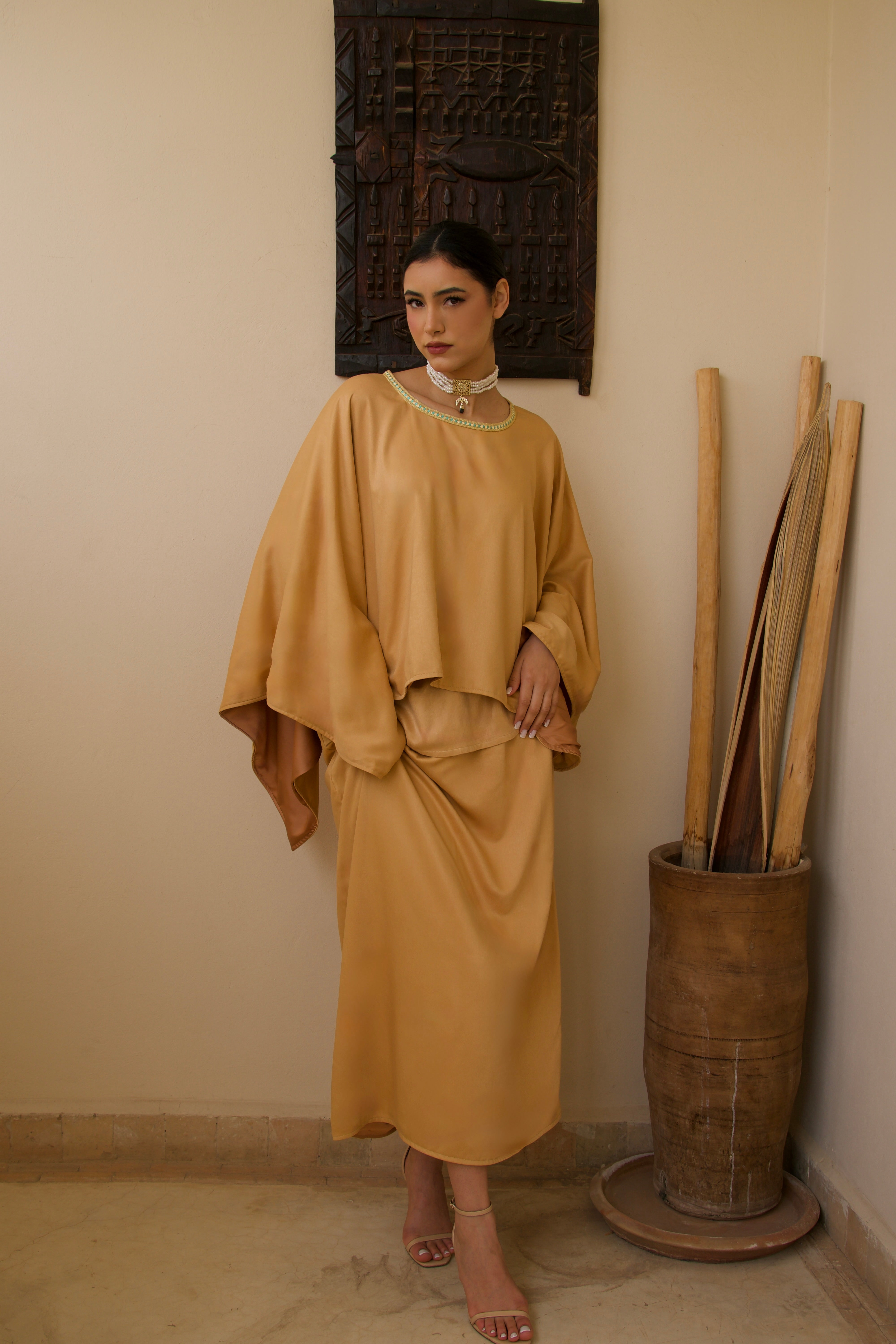 Orange mlifa silk cape and skirt set worn in motion, flowing and luminous fabric.
