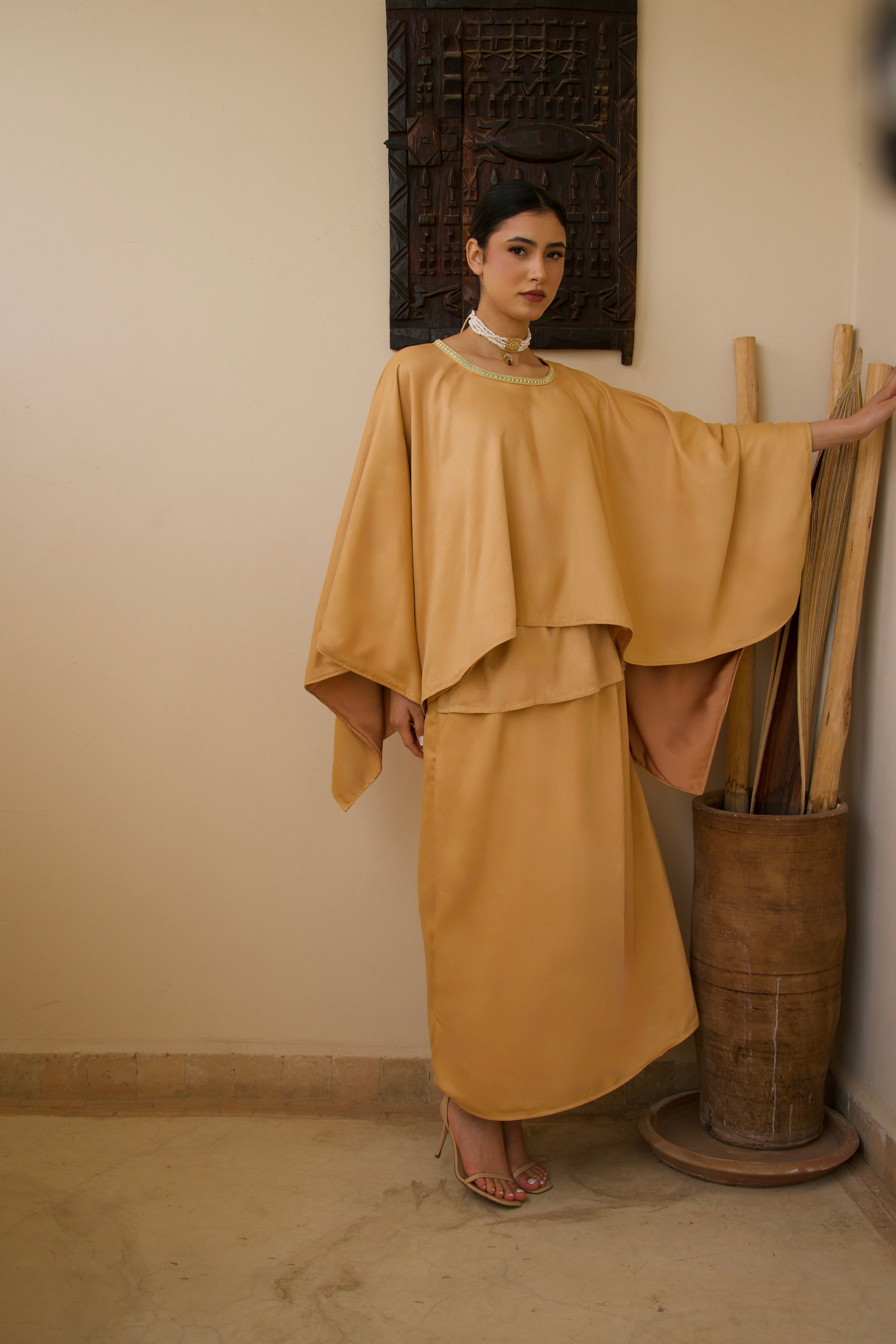 Orange ensemble consisting of a cape and a mlifa silk skirt, seen from the front.