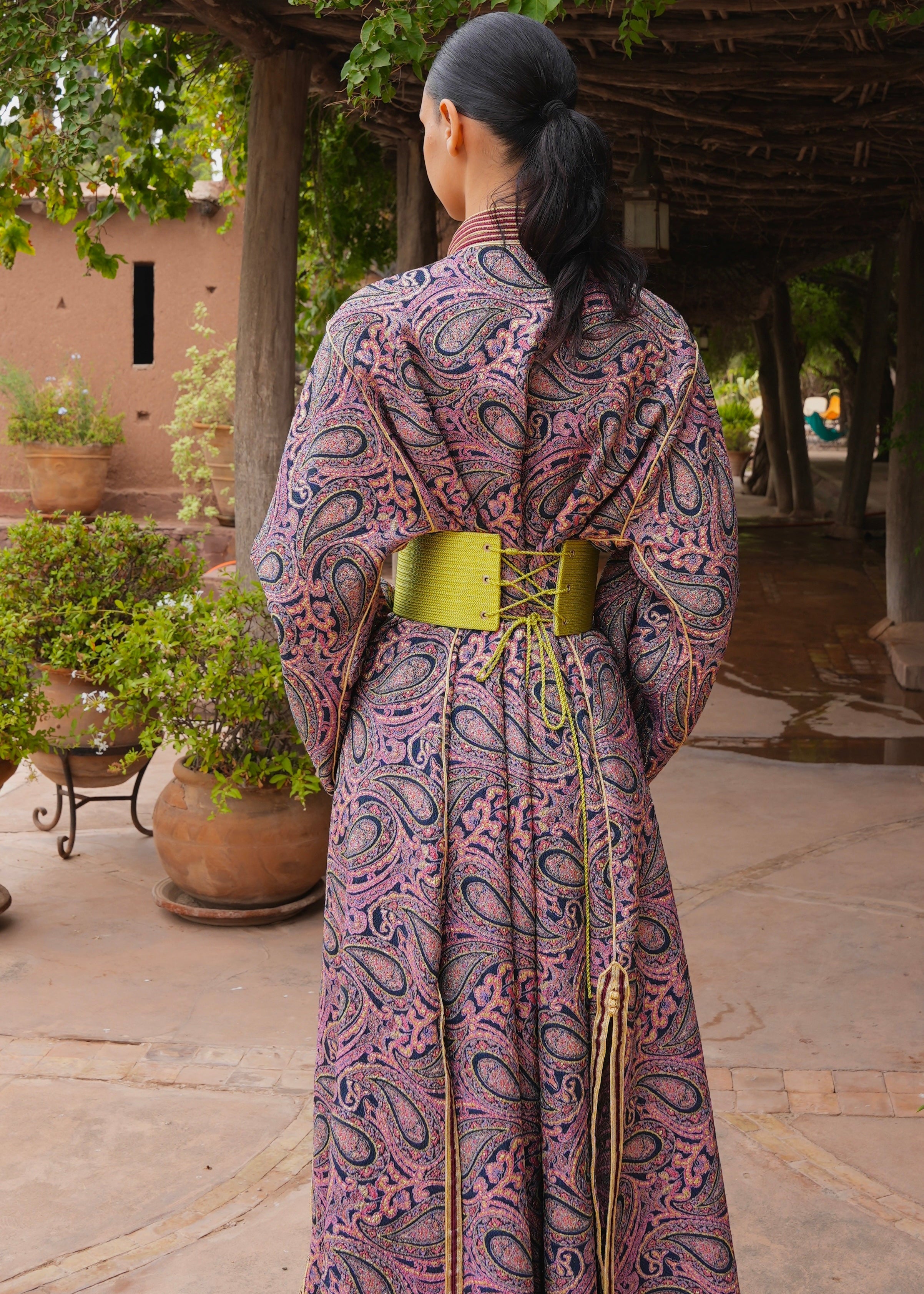 Rear view of the burgundy and green brocade collar Kaftan , highlighting the cut and finishings.
