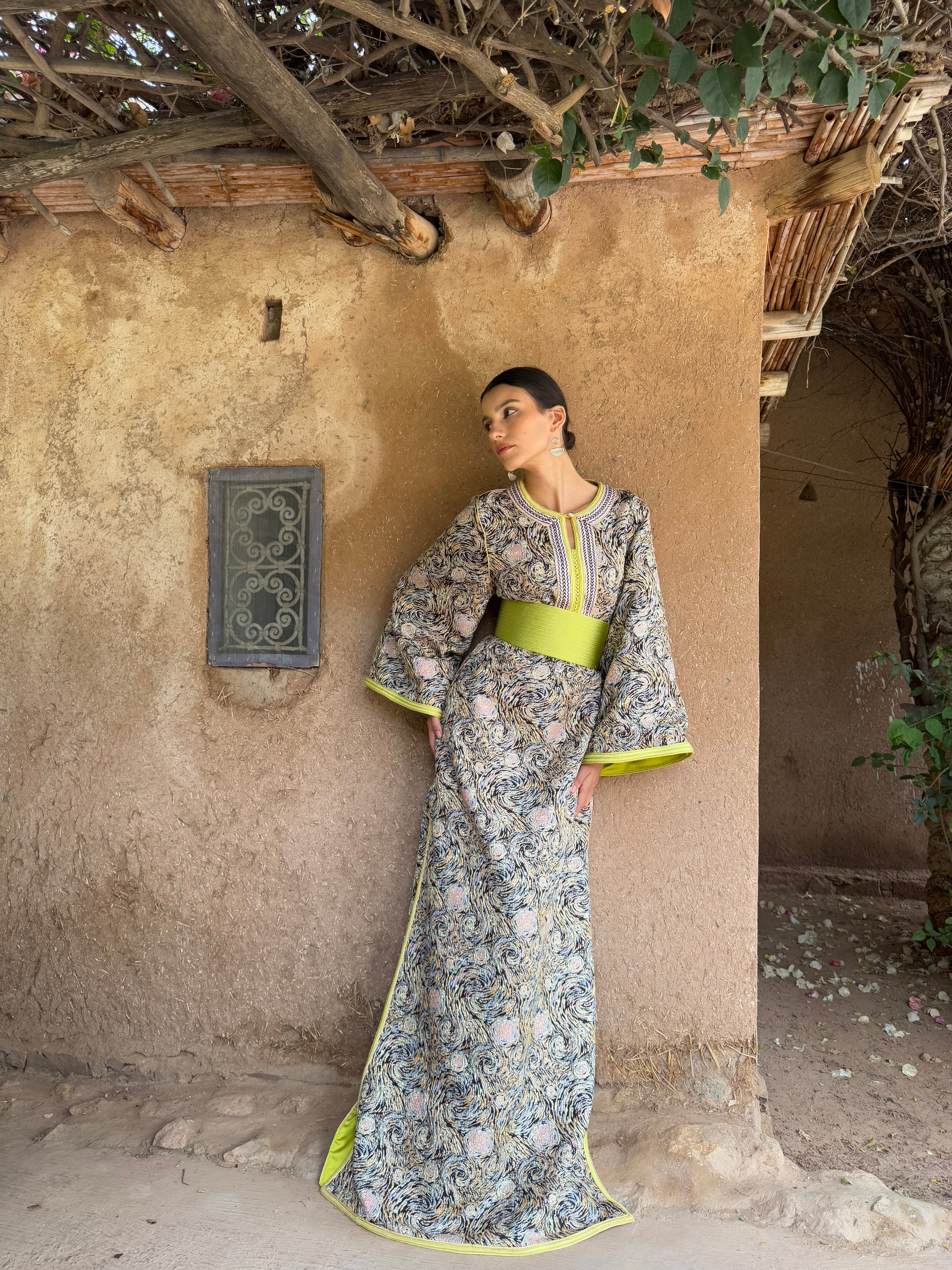 Full-length view of a model wearing a multicolored brocade Kaftan with green details