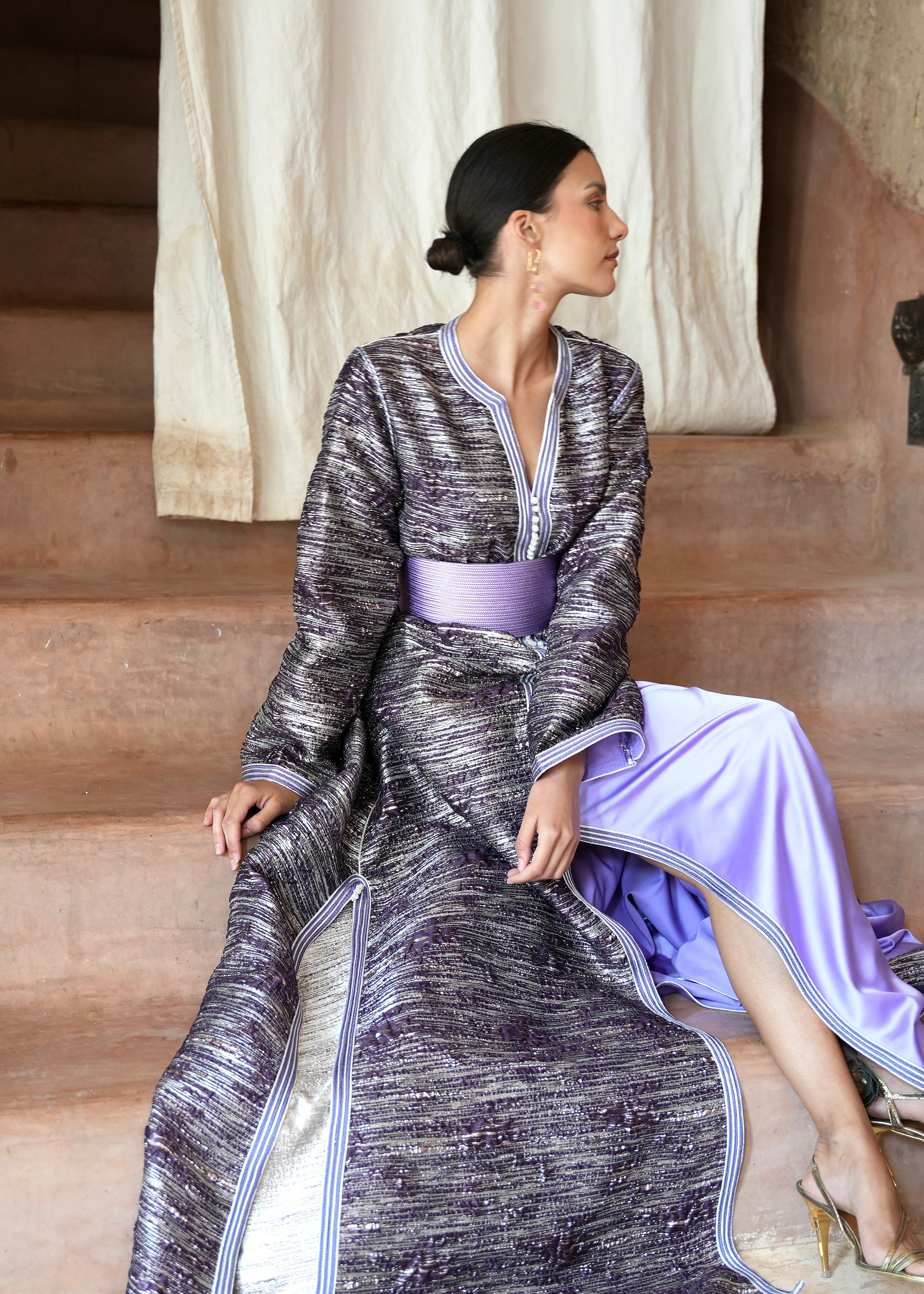 Seated woman wearing a purple brocade Kaftan , elegant and refined posture