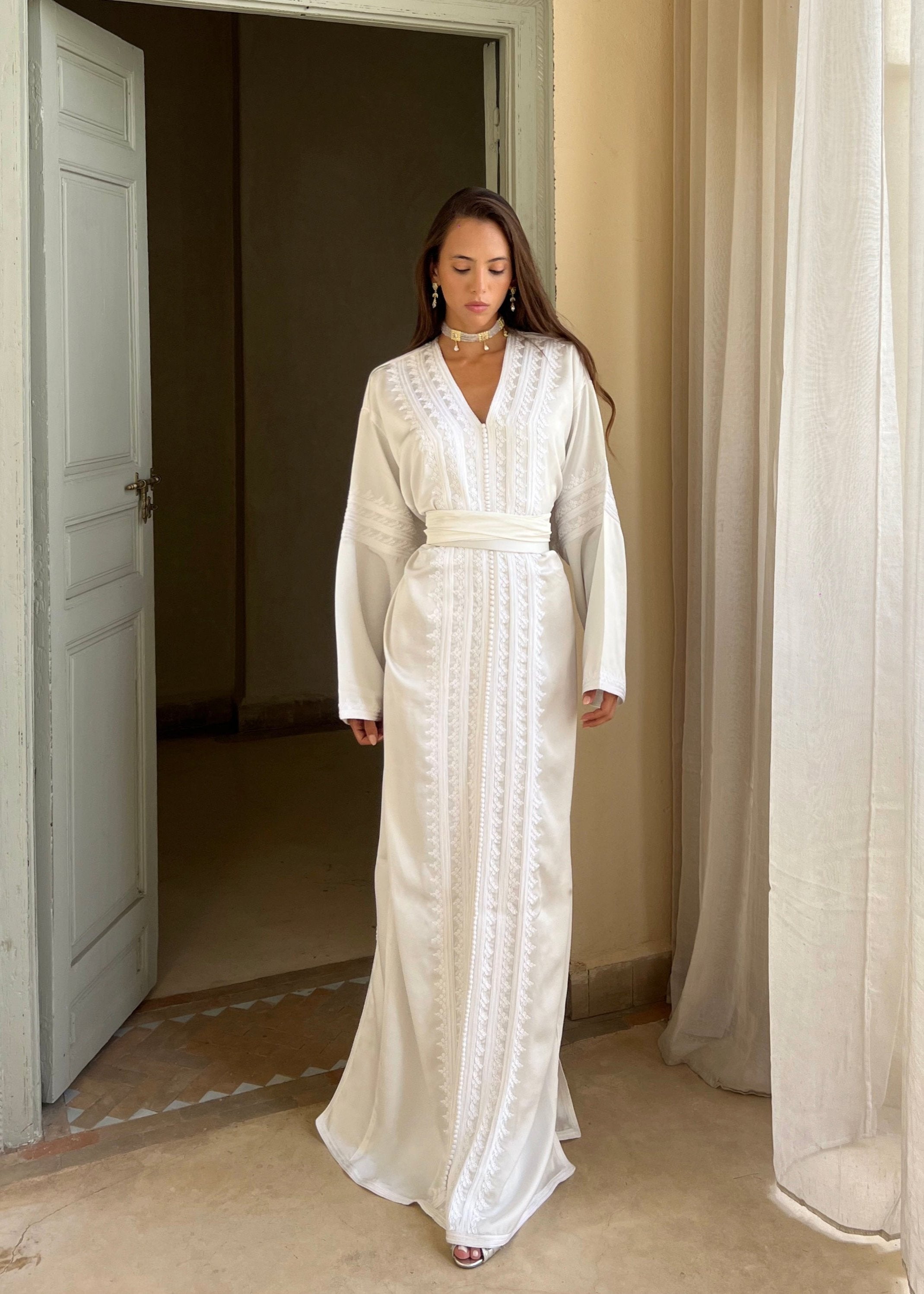 Kaftan in white silk drape seen from the front, featuring a flowing cut and the timeless elegance of white.