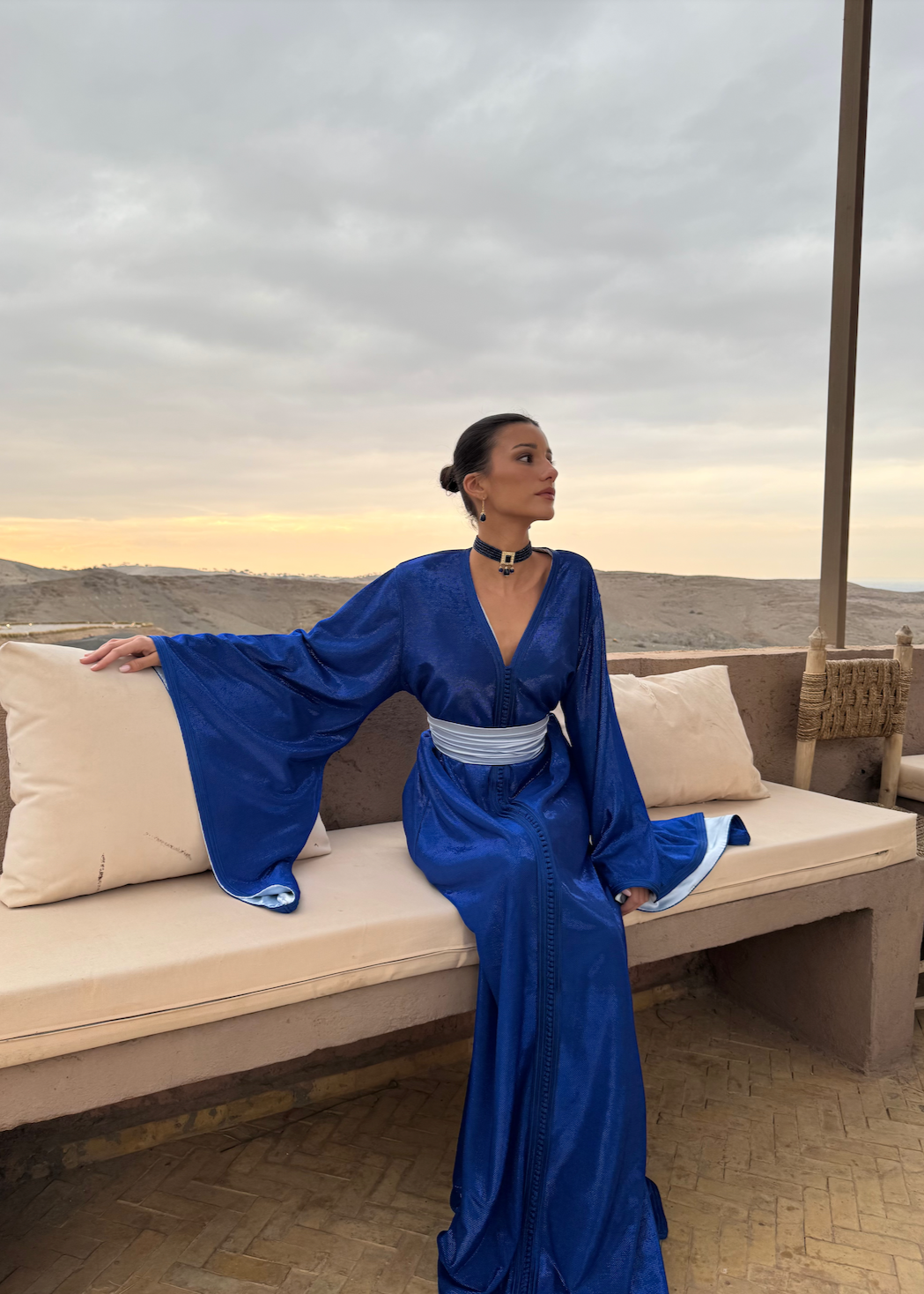 Kaftan in blue sequined silk lamé captured in motion, highlighting the shine of the fabric and the lightness of the drape.