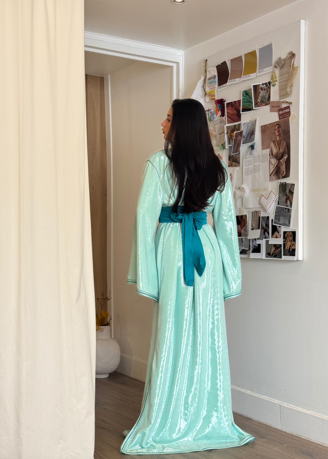 Kaftan in turquoise-blue sequined silk lamé seen from the back, highlighting the fluidity of the fabric and the sparkle of the sequins as they move.