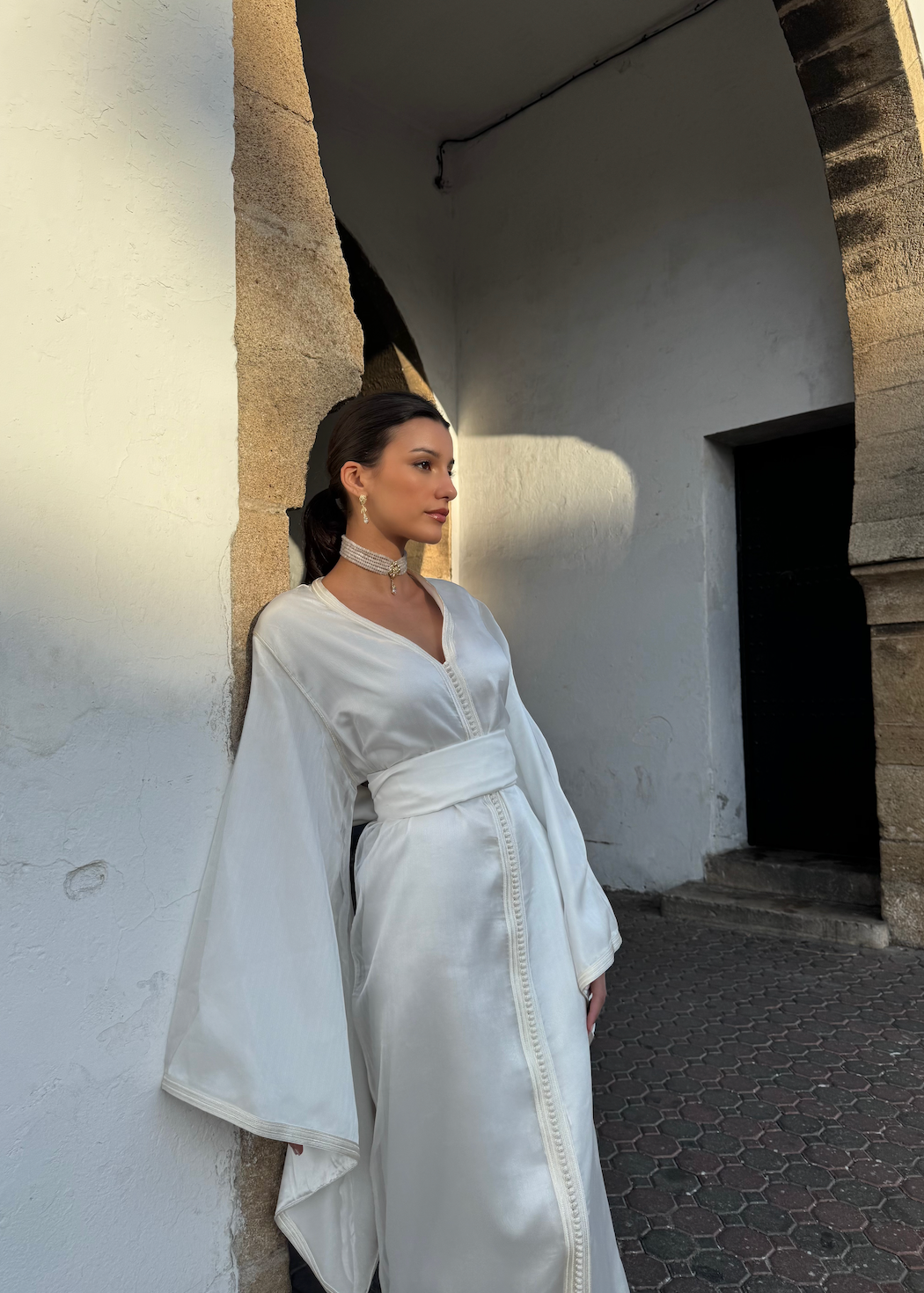 White organza bridal Kaftan seen in profile, highlighting the fluidity of the fabric and the timeless elegance of the silhouette.