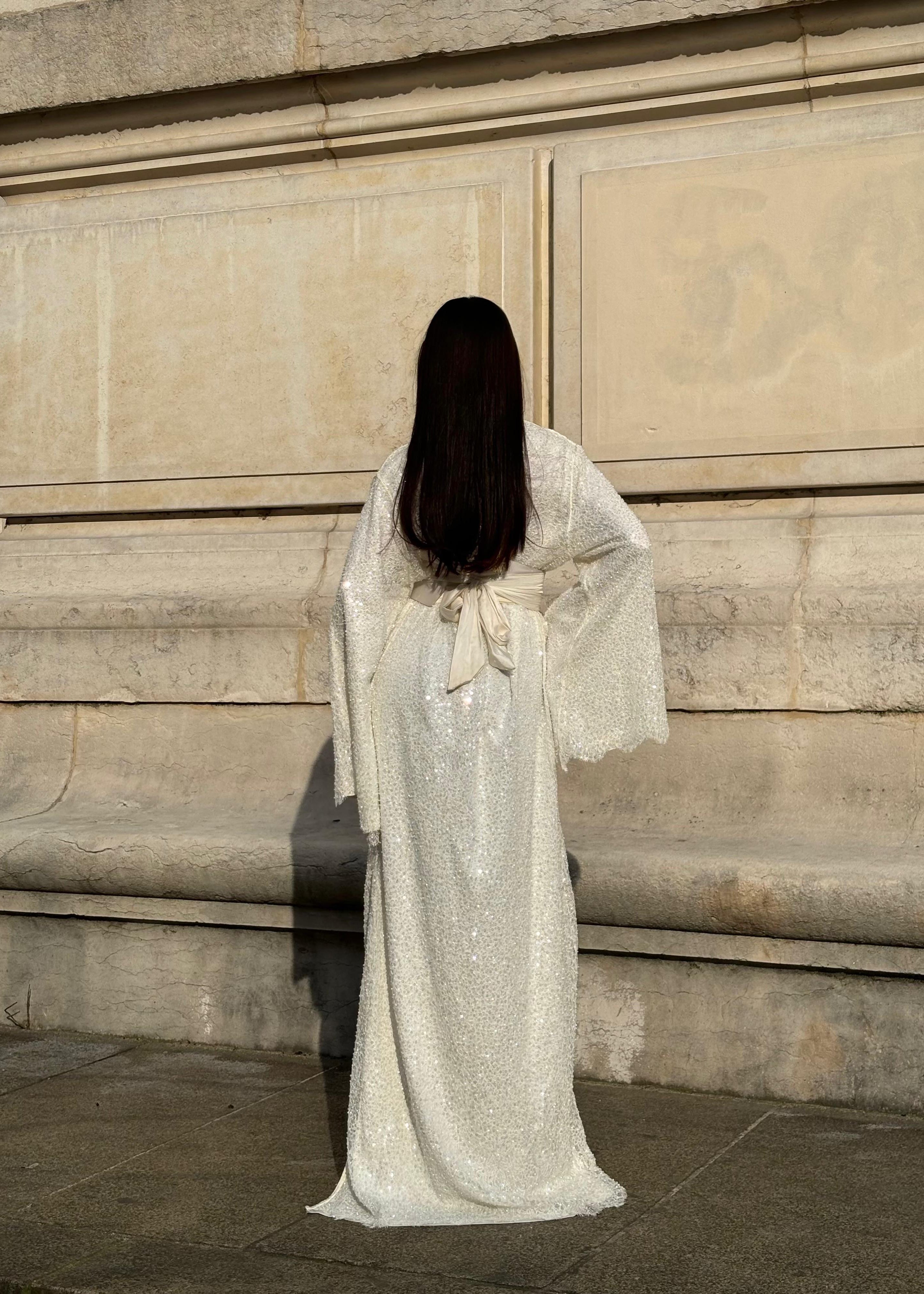 Beaded bridal Kaftan with flared sleeves seen from the back, revealing the fluidity of the fabric and the delicacy of the beaded embroidery.