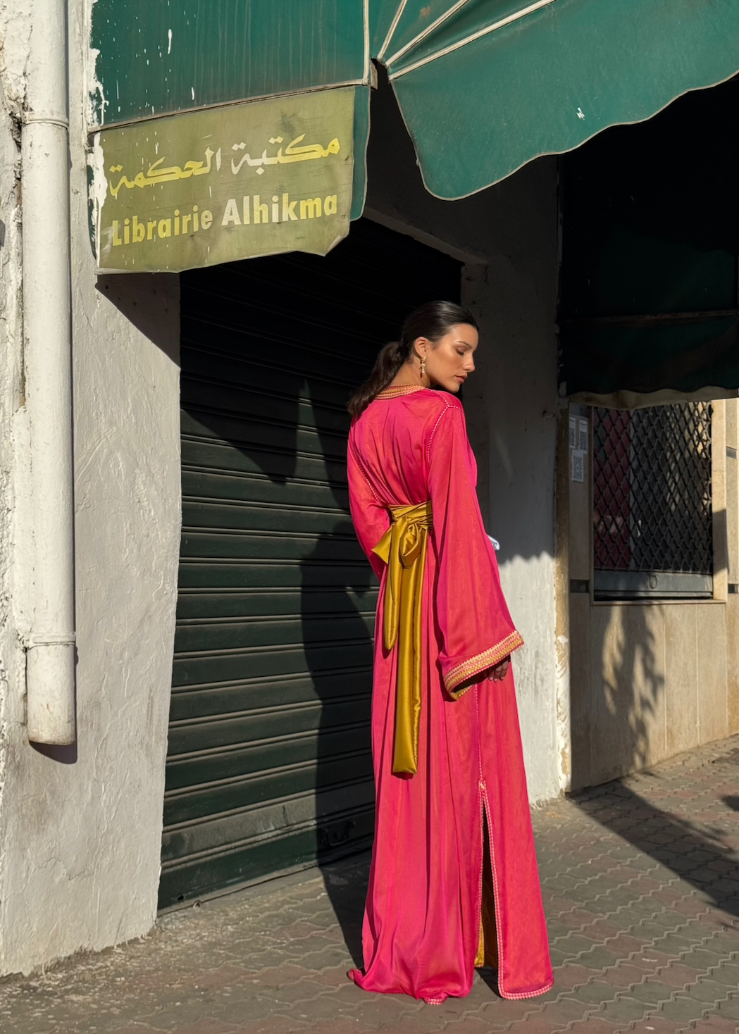 Kaftan in fuchsia-pink chiffon seen from the back, revealing the delicate transparency of the chiffon and the softness of the fall.