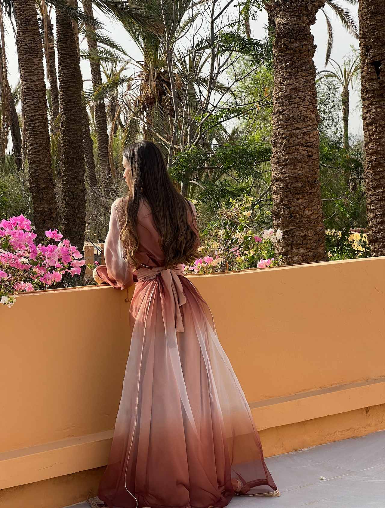 Kaftan in pink and brown organza seen from the back, revealing the delicate transparency of the fabric and the subtle harmony of colors.