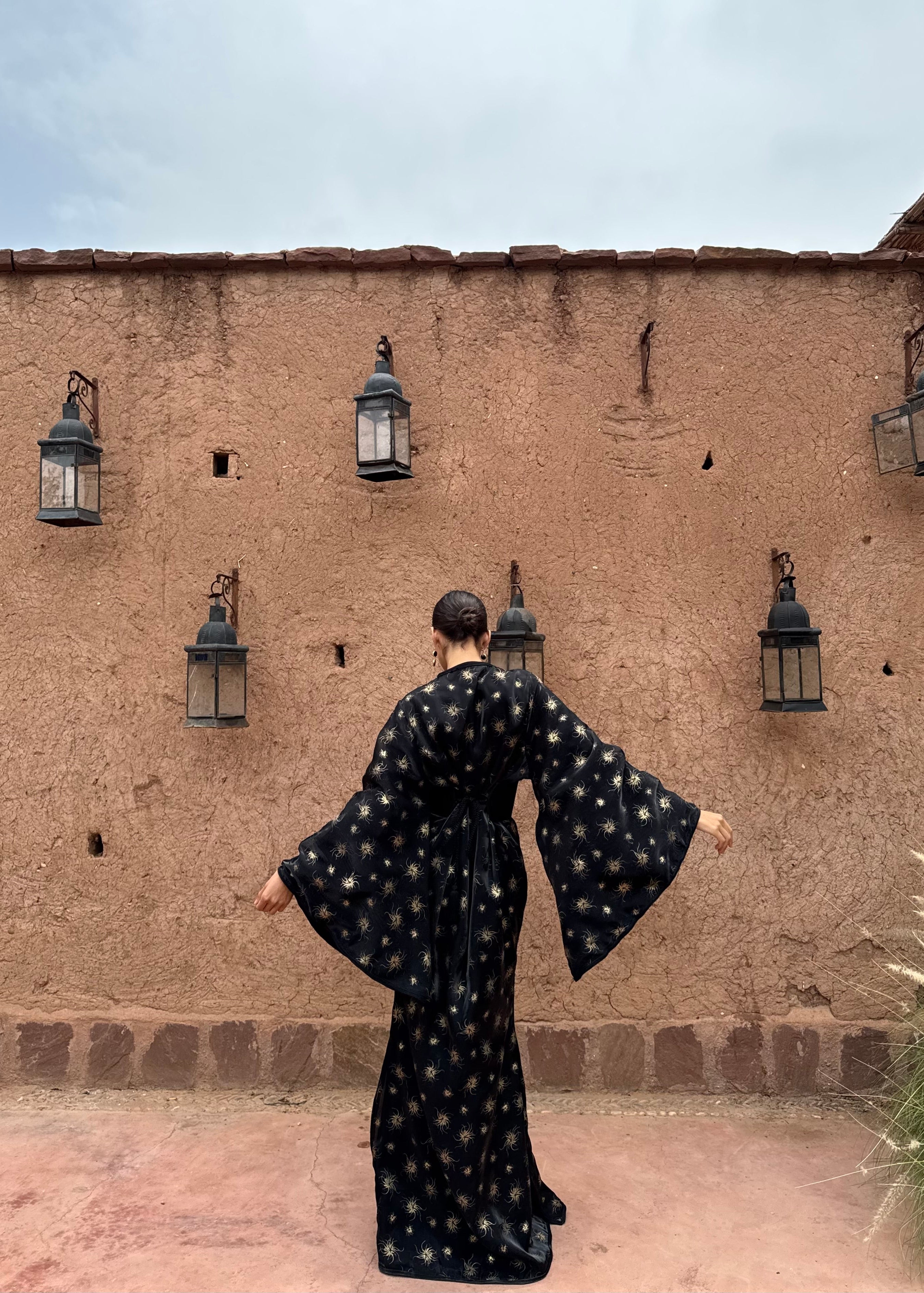 Back view of the black organza evening Kaftan with gold print, details and elegant cut