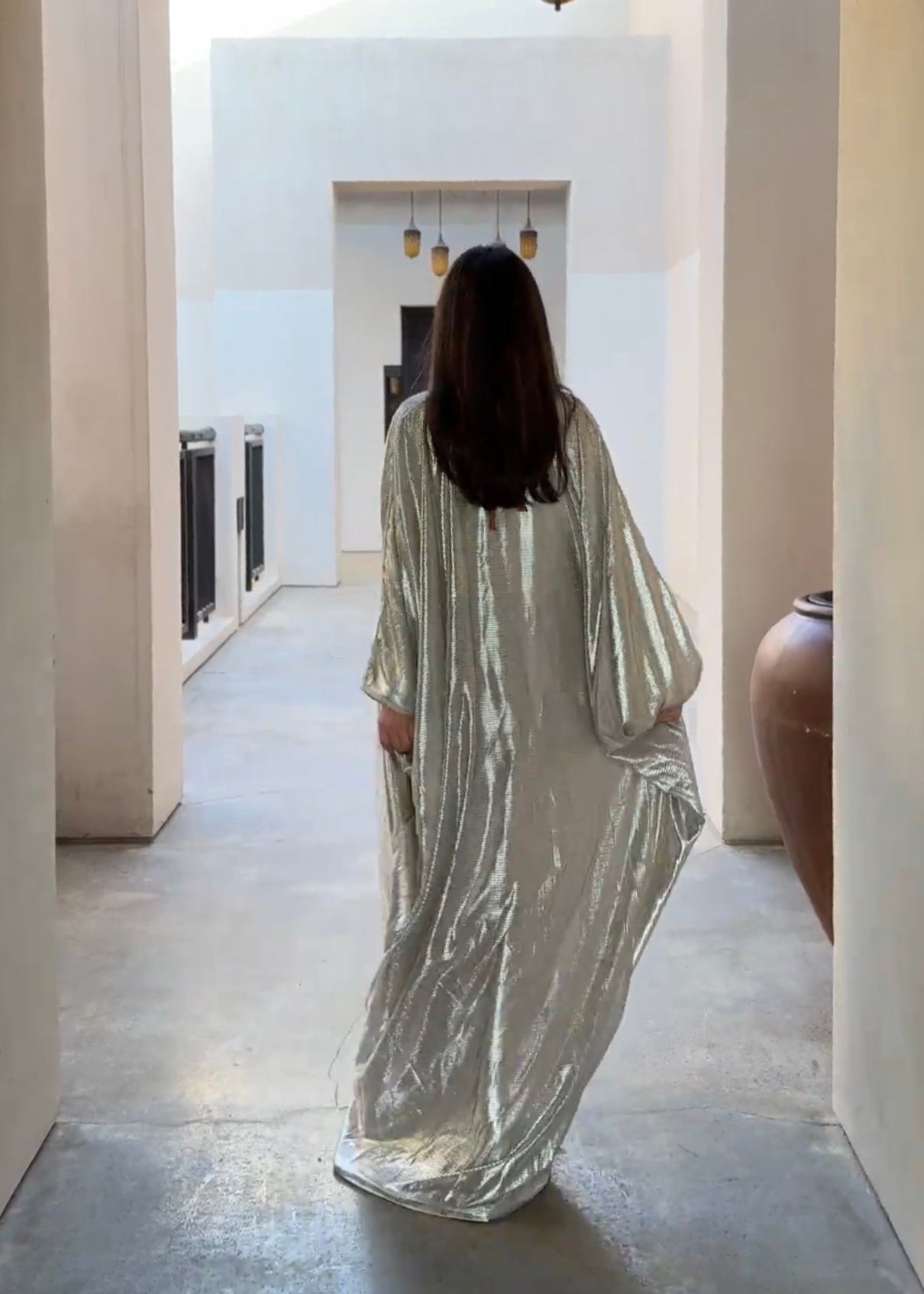 Kaftan in silver-pearl tulle with butterfly details seen from the back, revealing the lightness of the tulle and the delicacy of the pearls and butterfly motifs.