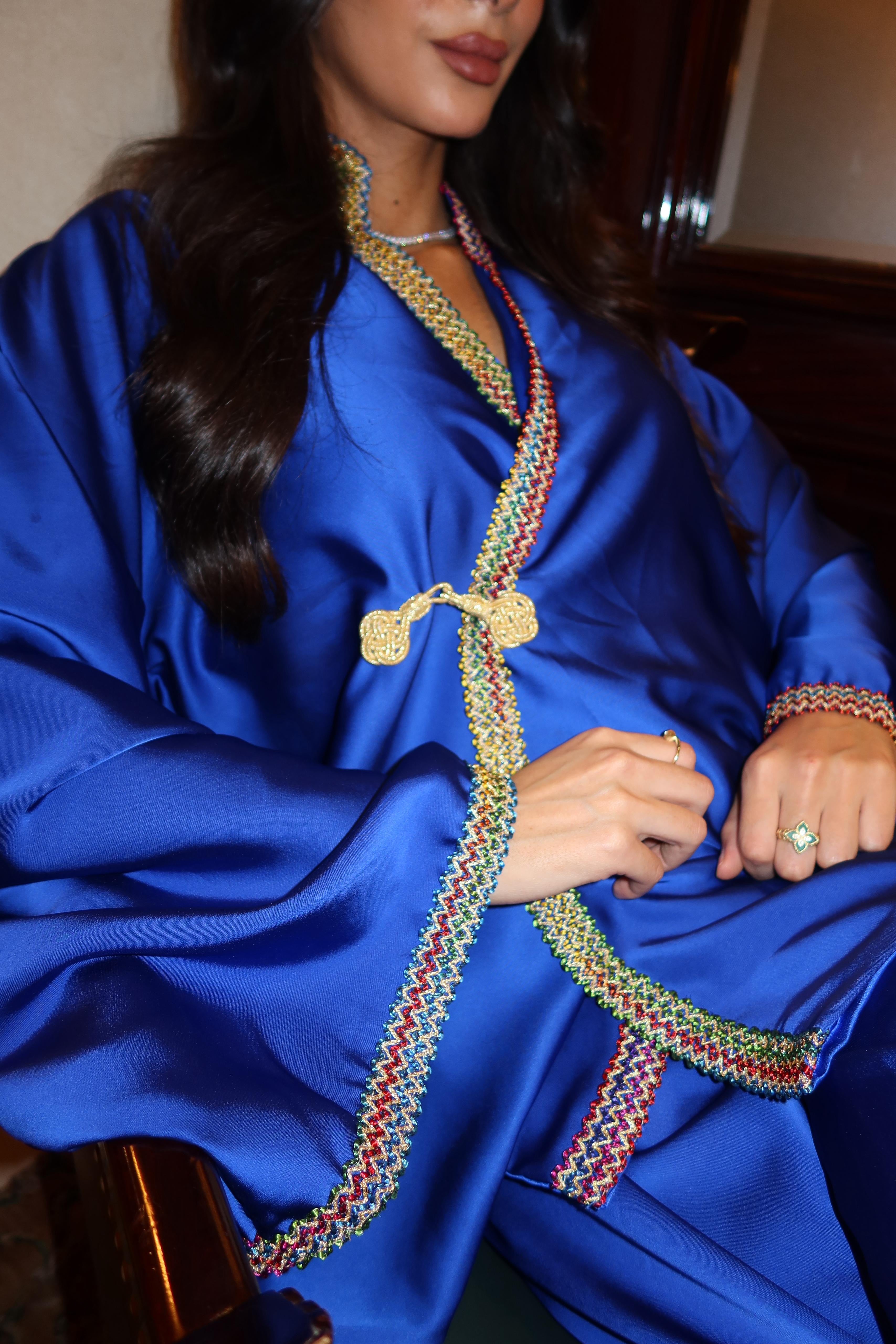 Close-up of the Kabyle embroidery and officer's collar finishing on the royal blue silk cloth ensemble.