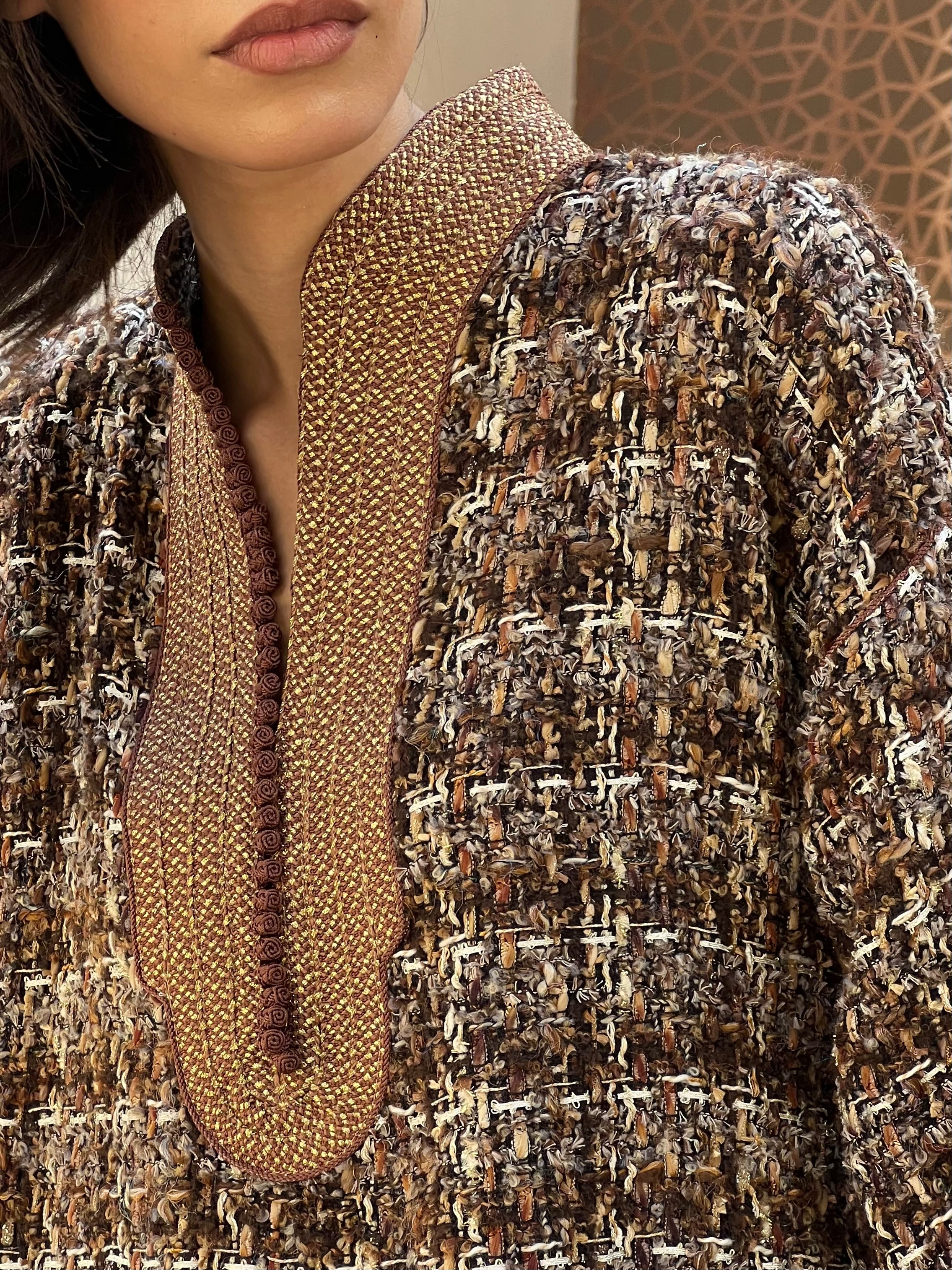 Detail of the collar adorned with sfifa on a brown tweed shirt, hand-crafted stitching and precise finishing.