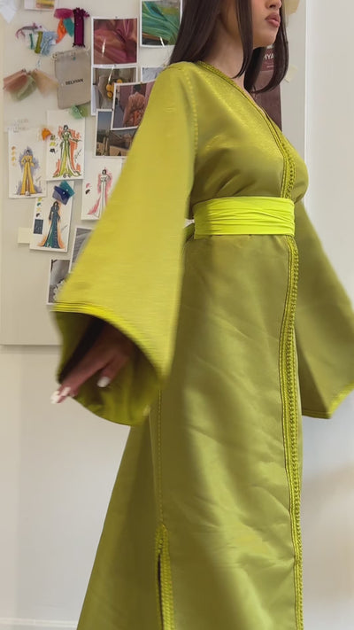 Video of a Kaftan in shiny green satin, elegantly flowing. A traditional Moroccan outfit ideal for ceremonies, parties or Oriental evenings.
