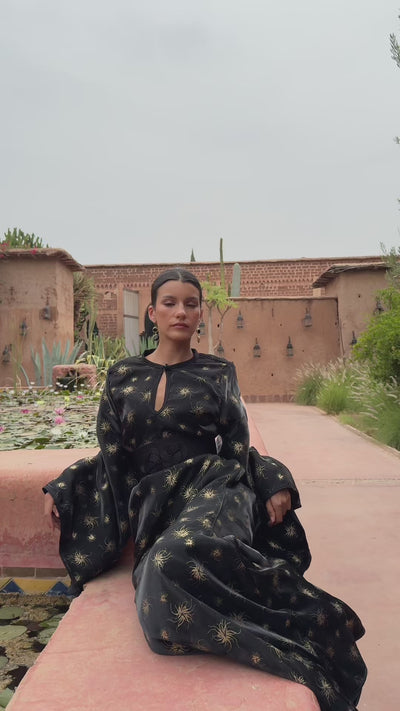 Video showing the black organza evening Kaftan with gold print worn in motion