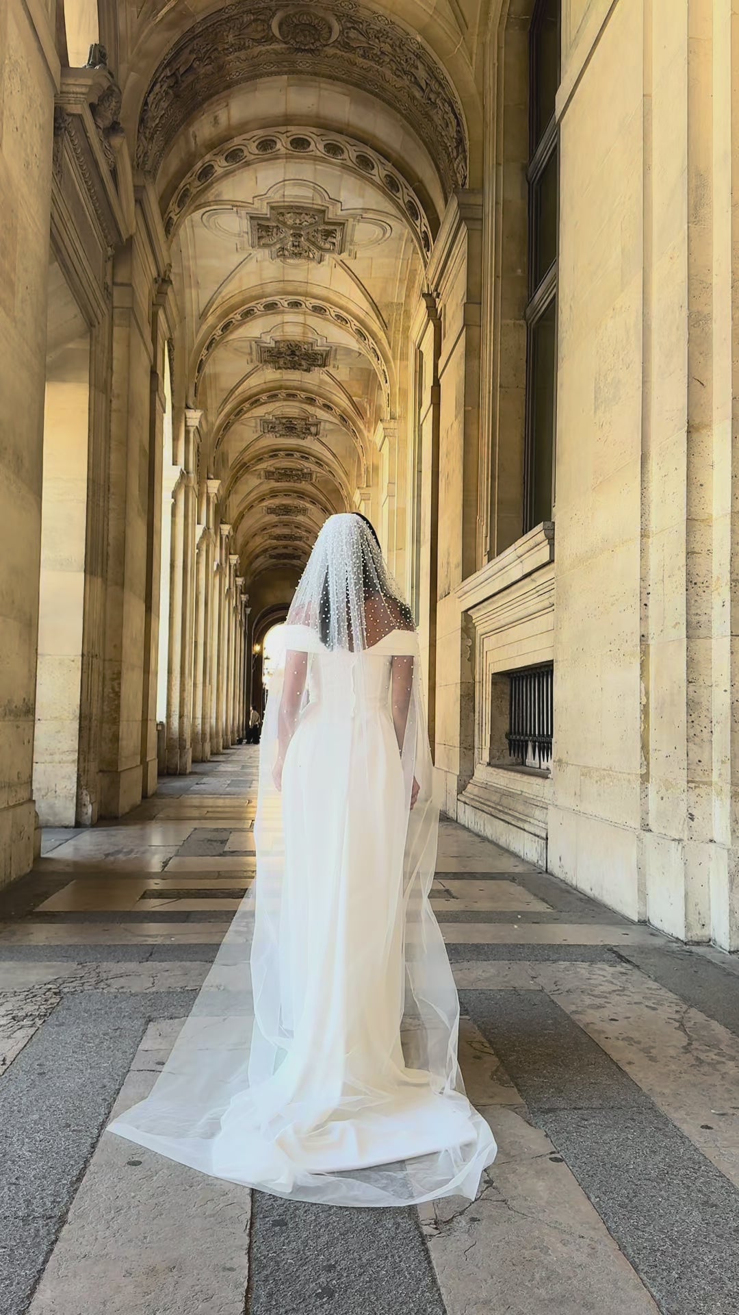 Video presentation of a long tulle bridal veil adorned with embroidered pearls, seen from different angles.