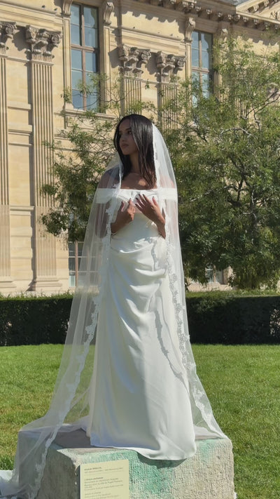 Presentation video of a long bridal veil with floral lace trim, showing the veil from different angles.