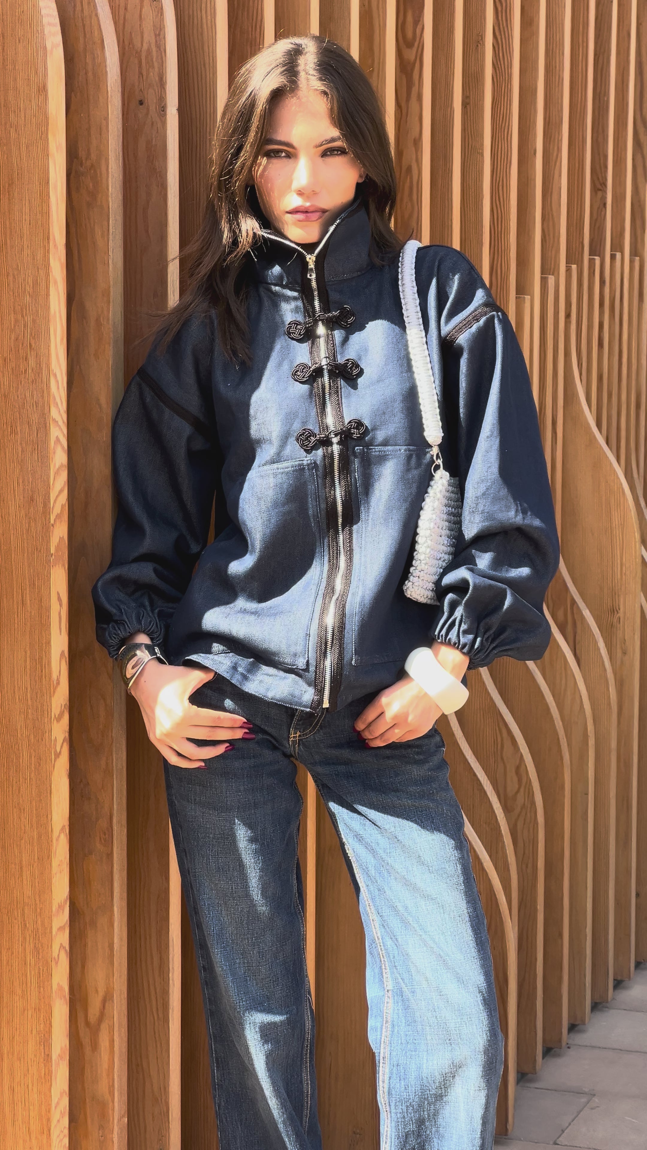 Zippered denim jacket adorned with black sfifa and Moroccan taîria, a modern garment inspired by traditional craftsmanship.
