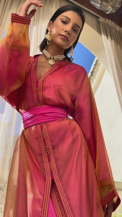 Video of a Kaftan in orange and pink organza, worn by a model, illustrating the lightness of the fabric and the vibrant gradations of color.