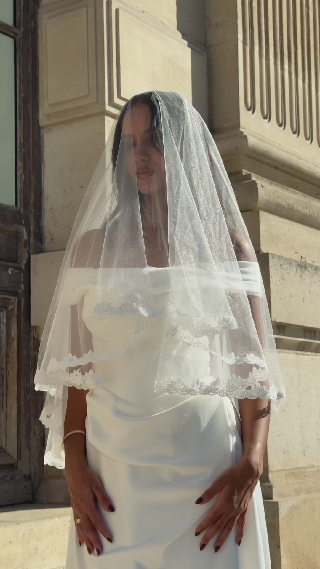 Video of short bridal veil with floral lace trim, shown from several angles and in motion
