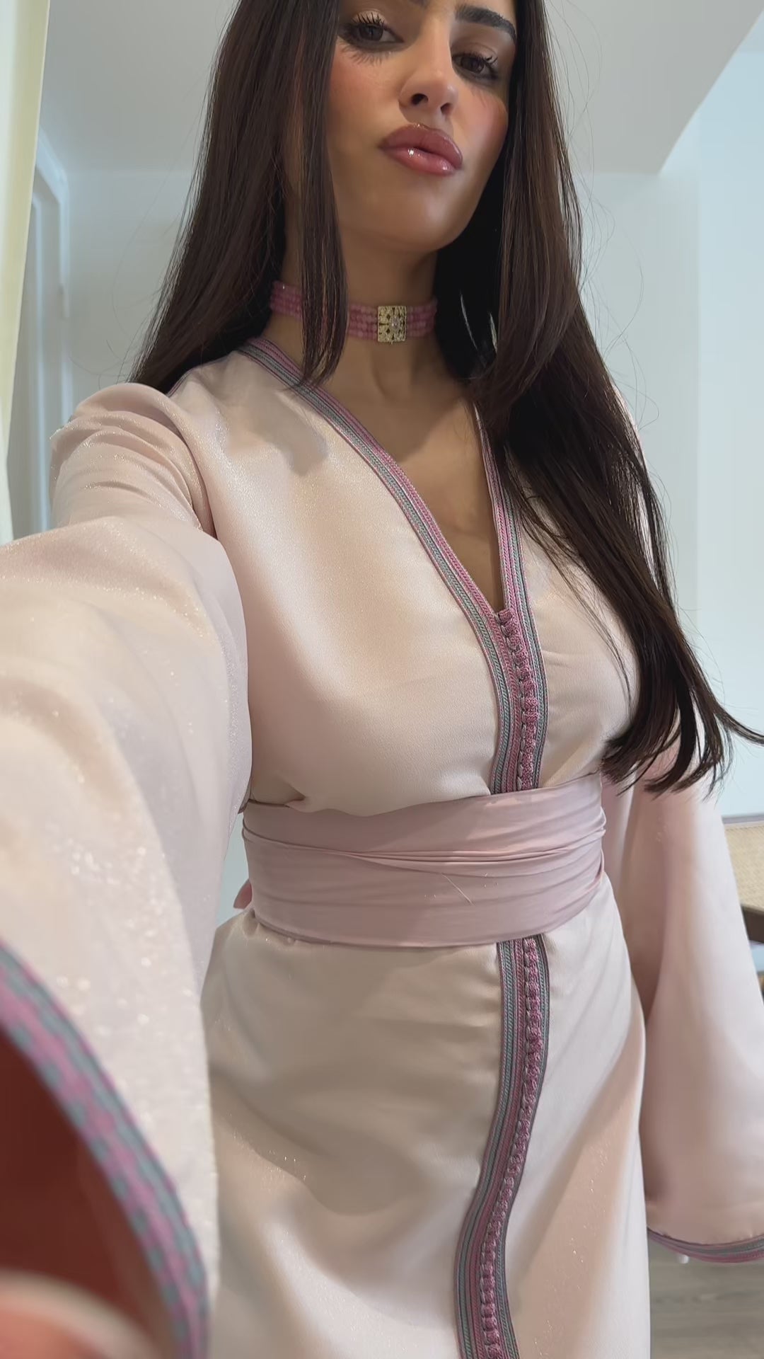 Video of a pink satin Kaftan worn by a model, highlighting the brilliance of the fabric, the fluidity of the movement and the elegant details of the cut.