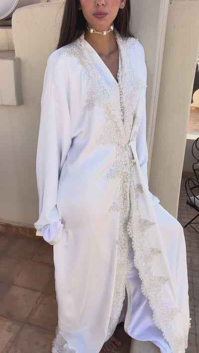 Video of the bridal Kaftan in white silk drape adorned with sequined lace, showing the fluidity of the fabric, the sparkling reflections and the elegant hand-crafted finishes.