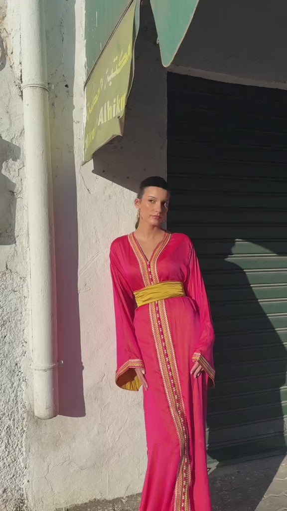 Video of a fuchsia-pink chiffon Kaftan presented on a mannequin. The flowing, lightweight fabric highlights the garment's elegant details, with graceful movements as you walk.