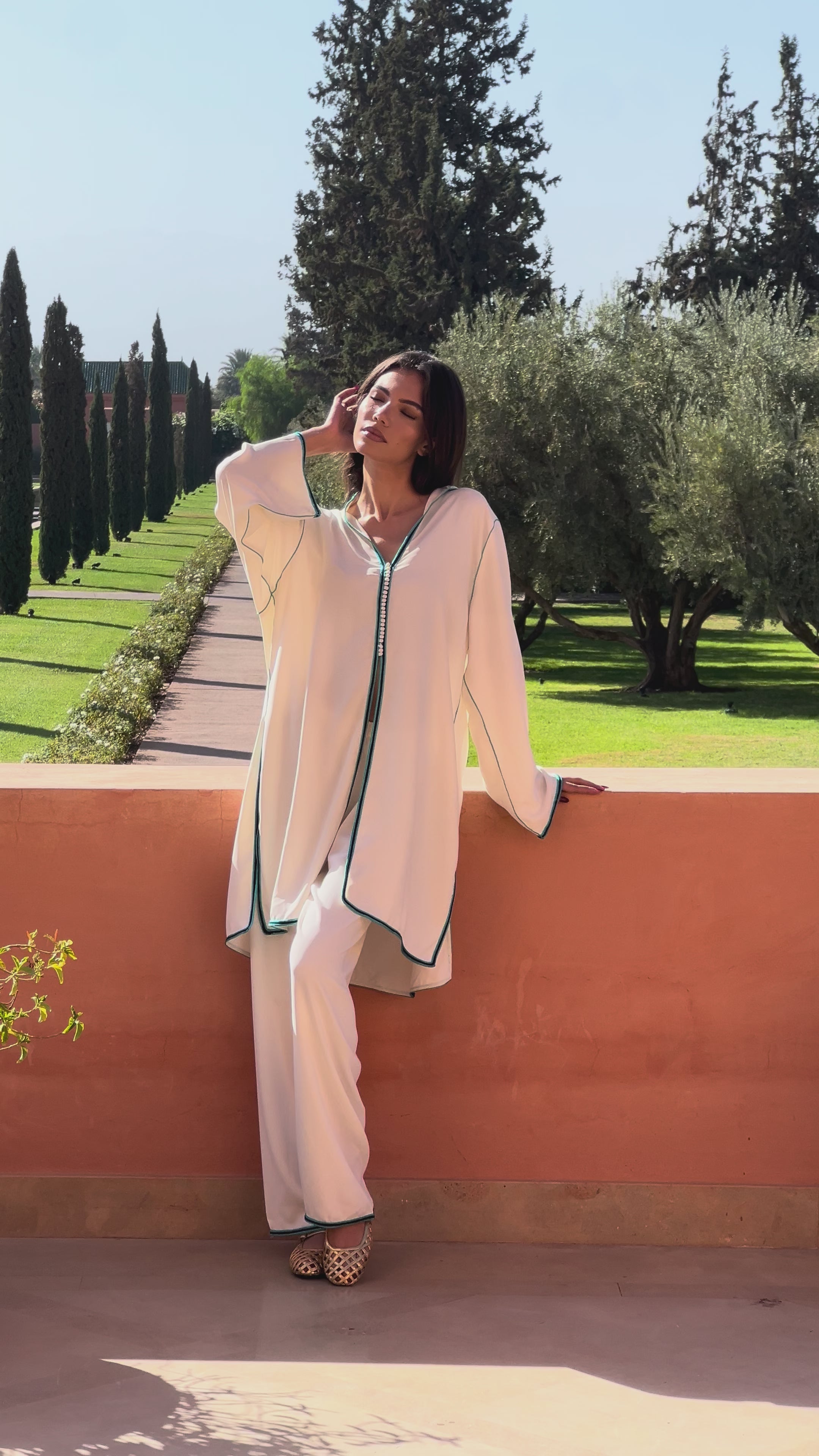 White silk crepe tunic and pants ensemble adorned with blue sfifa, elegant Moroccan craftsmanship.
