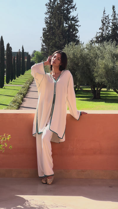 White silk crepe tunic and pants ensemble adorned with blue sfifa, elegant Moroccan craftsmanship.
