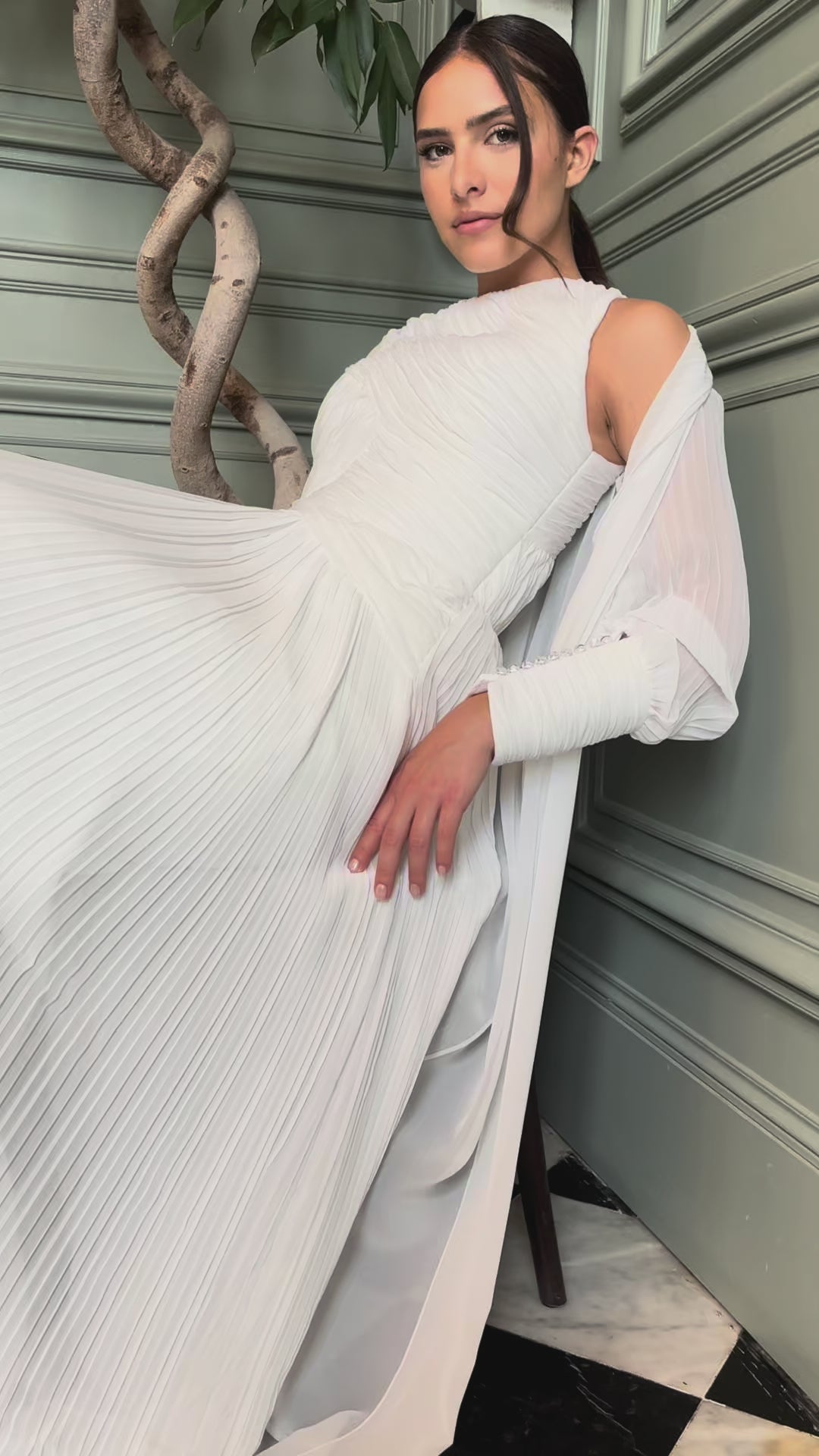 Video showing the pleated bridal cape in light tulle worn in motion, soft and romantic atmosphere