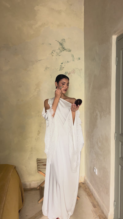 Video of a white silk bridal Kaftan with flowing angel sleeves and delicate lace trim - elegant and refined wedding attire.