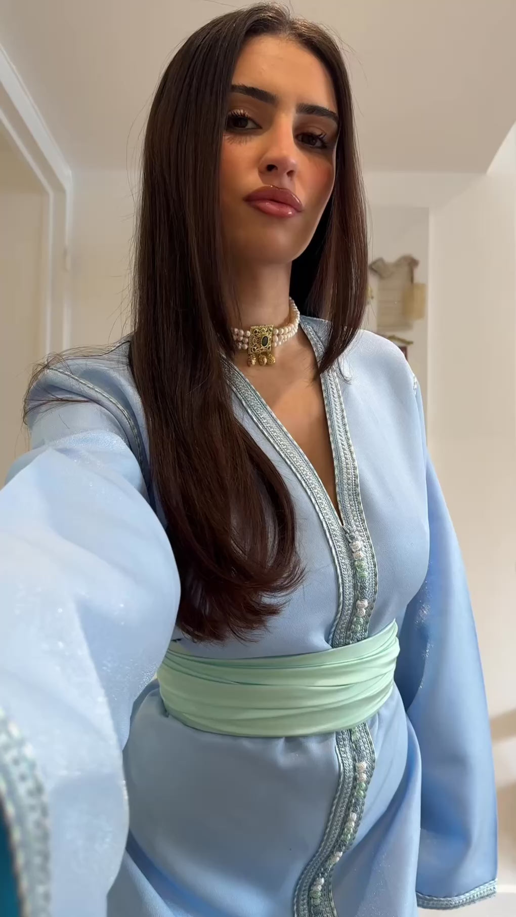 Video of a blue satin Kaftan , flowing and shiny, with an elegant cut. Traditional Moroccan attire ideal for evenings, ceremonies and festive events.
