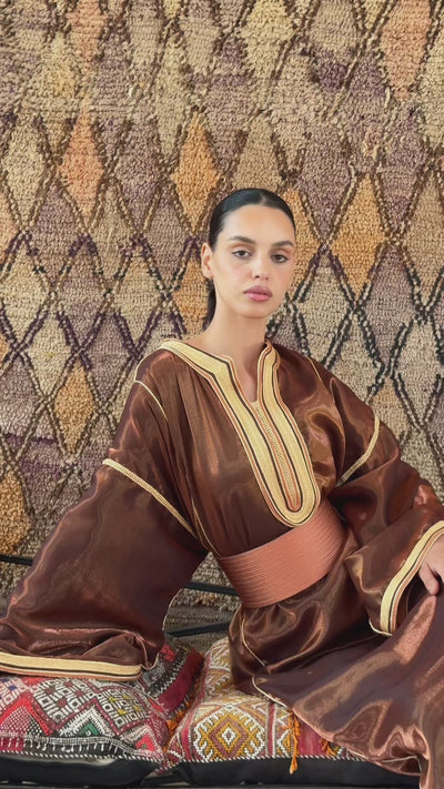 Global video showing the modern Kaftan in metallic bronze satin worn in motion, elegant ambiance
