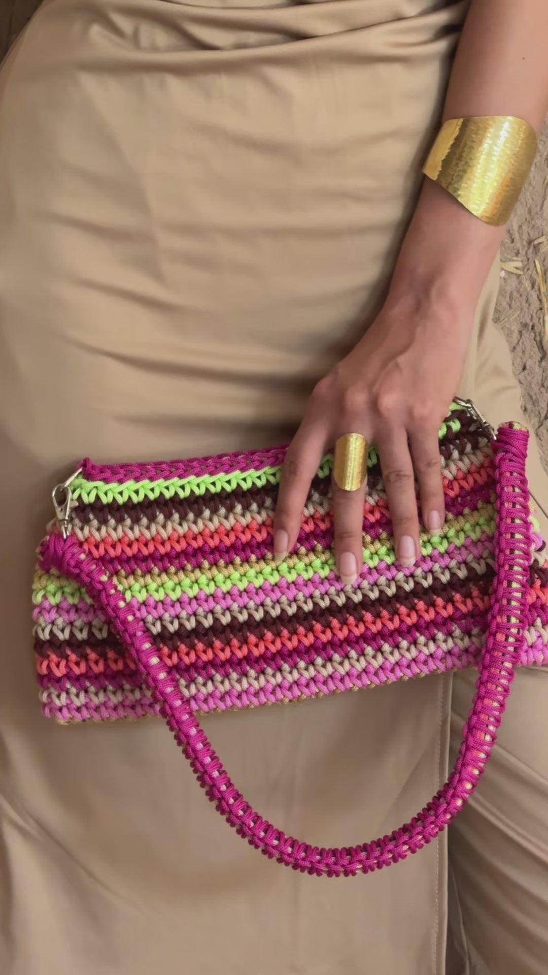 Lifestyle video showing the trapeze bag in multicolored pink crochet worn by a model, with a natural, handcrafted feel.