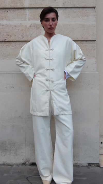 Video of beige cashmere ensemble with Moroccan buttons worn by a moving mannequin