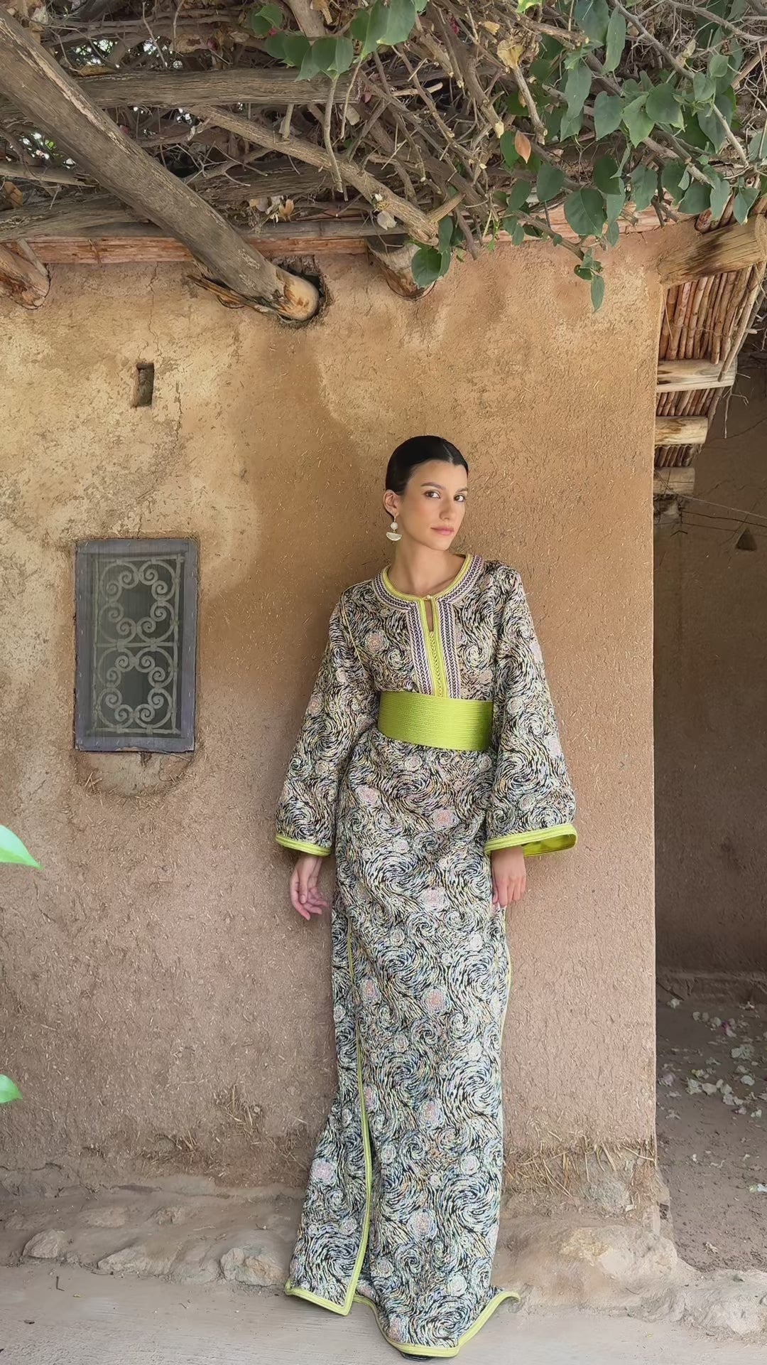 Global video showing the multicolored brocade Kaftan with green details worn in motion